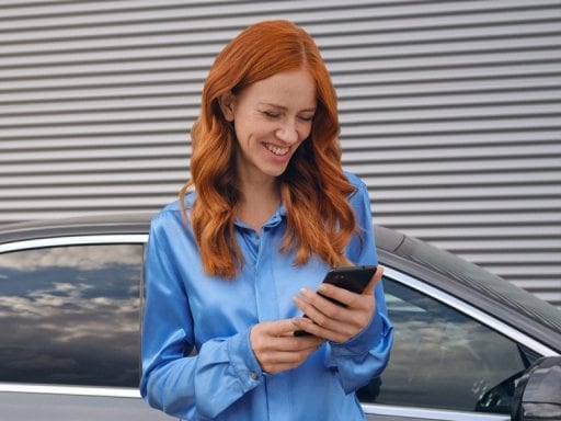 Žena vytváří přes aplikaci Mercedes me na svém chytrém telefonu spojení se svým vozidlem Mercedes-Benz.