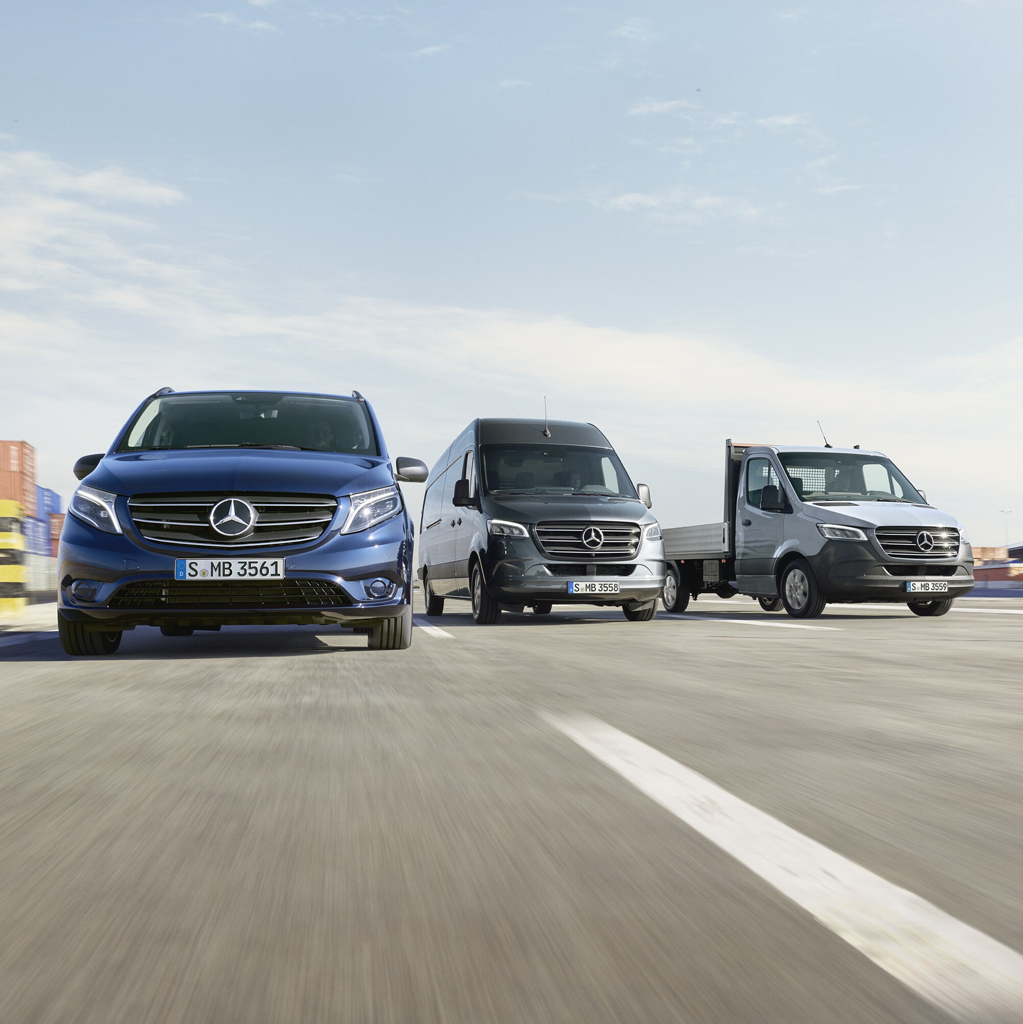 Dodávková vozidla Mercedes-Benz stojí vedle sebe v přístavu.