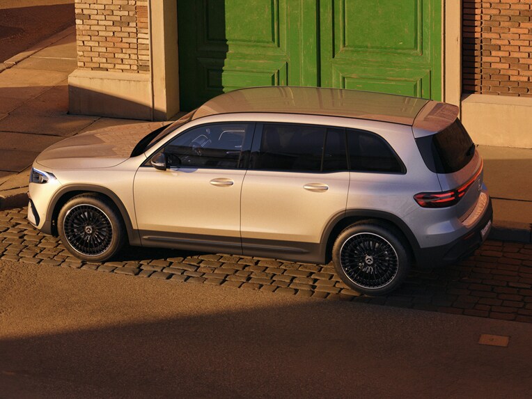 Two children sleep in the back of a Mercedes-Benz EQB, leaning on an octopus stuffed toy betweeen them.