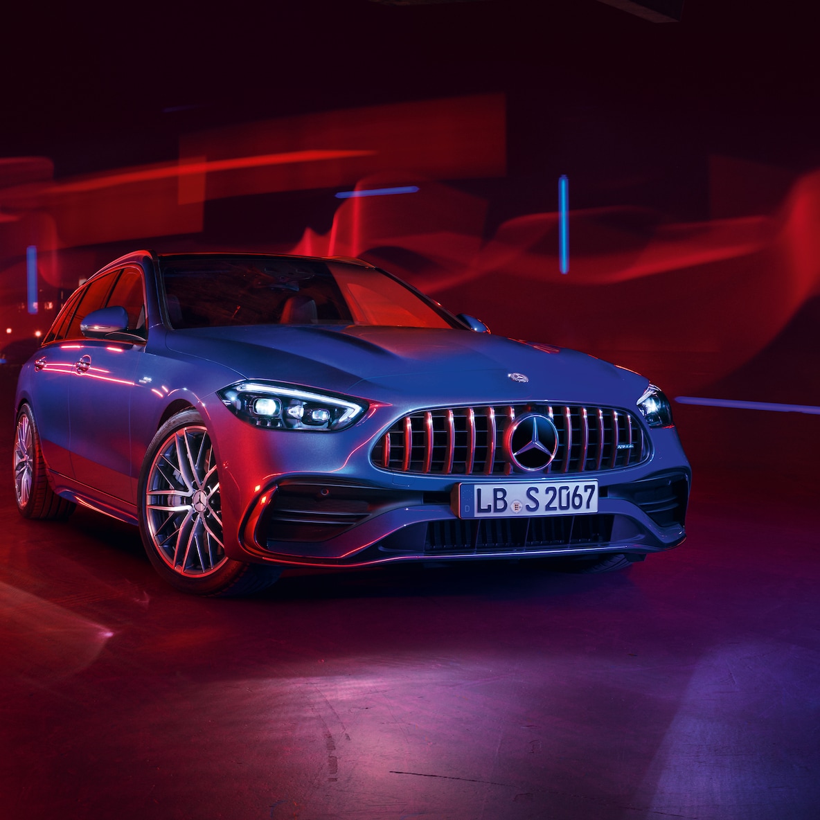 Mercedes-AMG C 43 při pohledu zepředu před červeným pozadím.