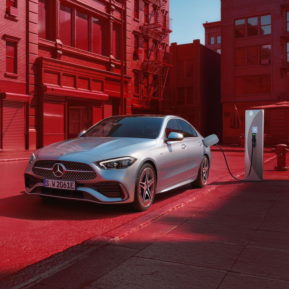 Dynamický pohled na Mercedes-Benz Třídy C sedan (záběr během jízdy) nebo během stání u nabíjecí stanice.