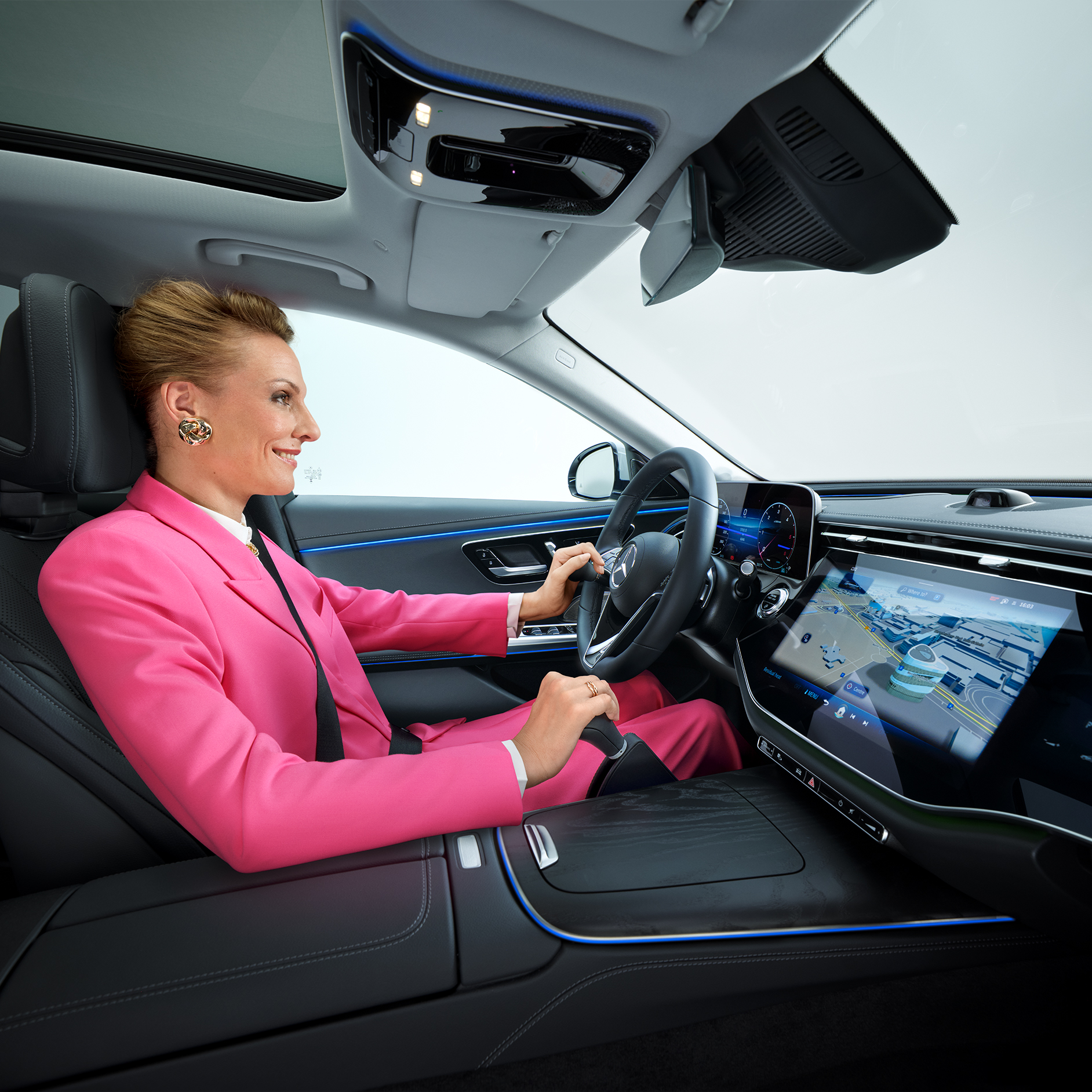 Průvodce „Více mobility“ | Pomůcky pro jízdu | Mercedes-Benz Třída E přestavěná pro invalidy, žena za volantem s madlem a zařízením pro ruční ovládání.