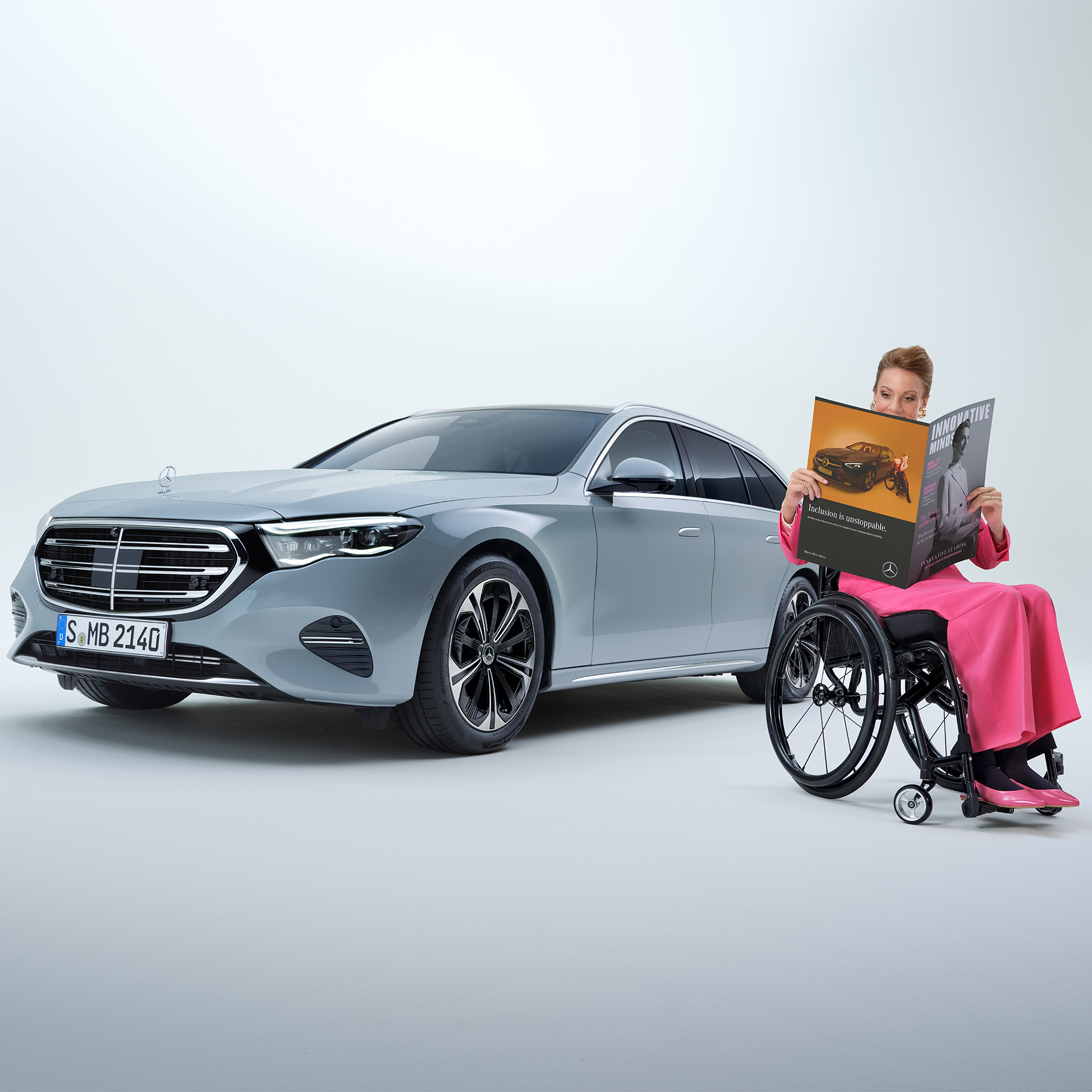 Pomůcky pro nastupování a vystupování | Pomůcky pro jízdu | Mercedes-Benz Pohled z boku na Třídu E kombi přestavěnou pro hendikepované osoby a na ženu na invalidním vozíku.