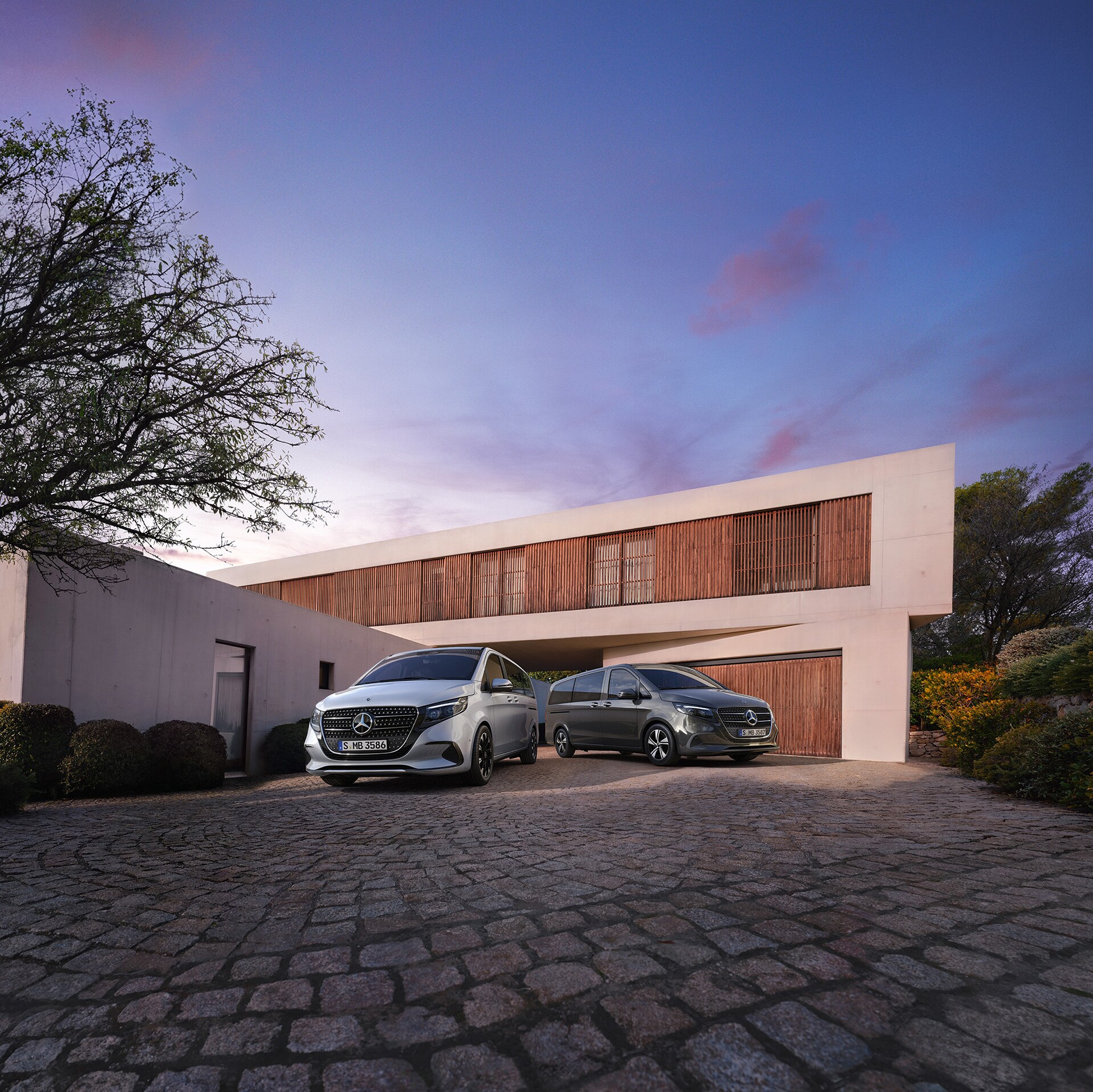 Mercedes-Benz Třídy V před moderním luxusním domem za soumraku.