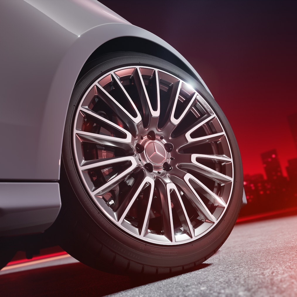 Detailní záběr na kované kolo AMG s vysoce výkonnou kompozitní brzdovou soustavou AMG s červeně lakovanými třmeny kotoučových brzd.