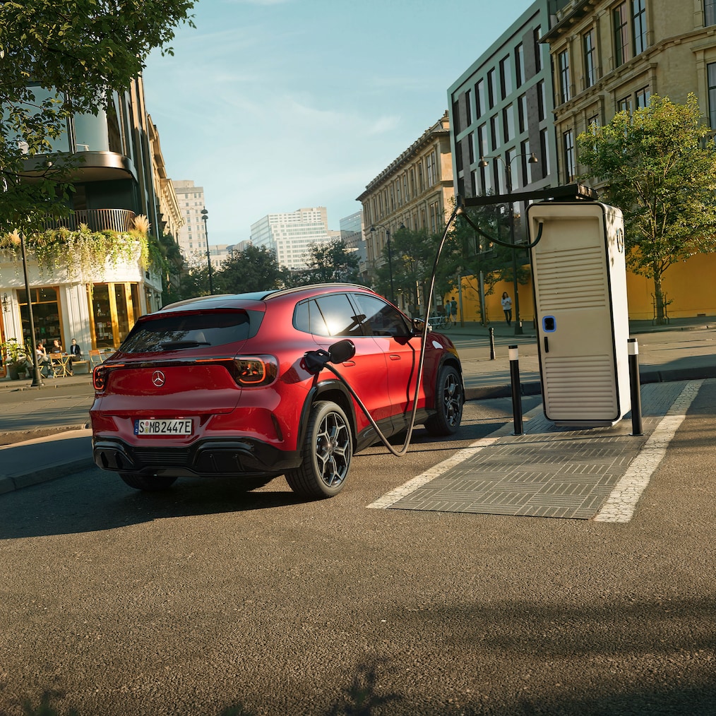 Zcela nové elektrické vozidlo Mercedes-Benz GLA zaparkované u&nbsp;nabíjecí stanice pro elektromobily.
