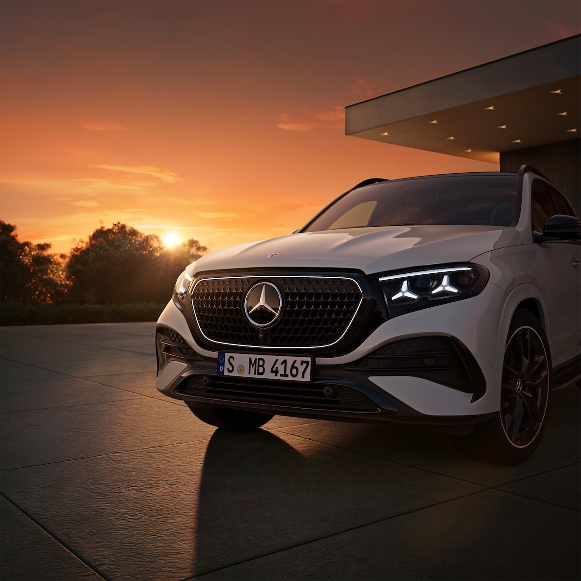 Osvětlený obrys masky chladiče a charakteristické světlomety v designu hvězd vozu Mercedes-Benz GLE.