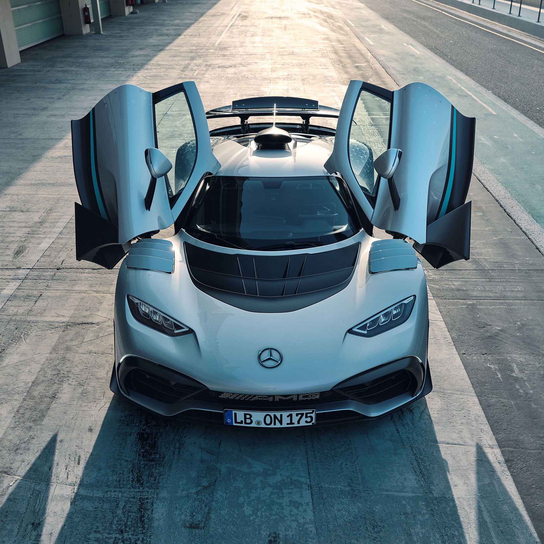 Exteriér | ONE | Mercedes-AMG Mercedes-AMG ONE s otevřenými dveřmi při pohledu zepředu.