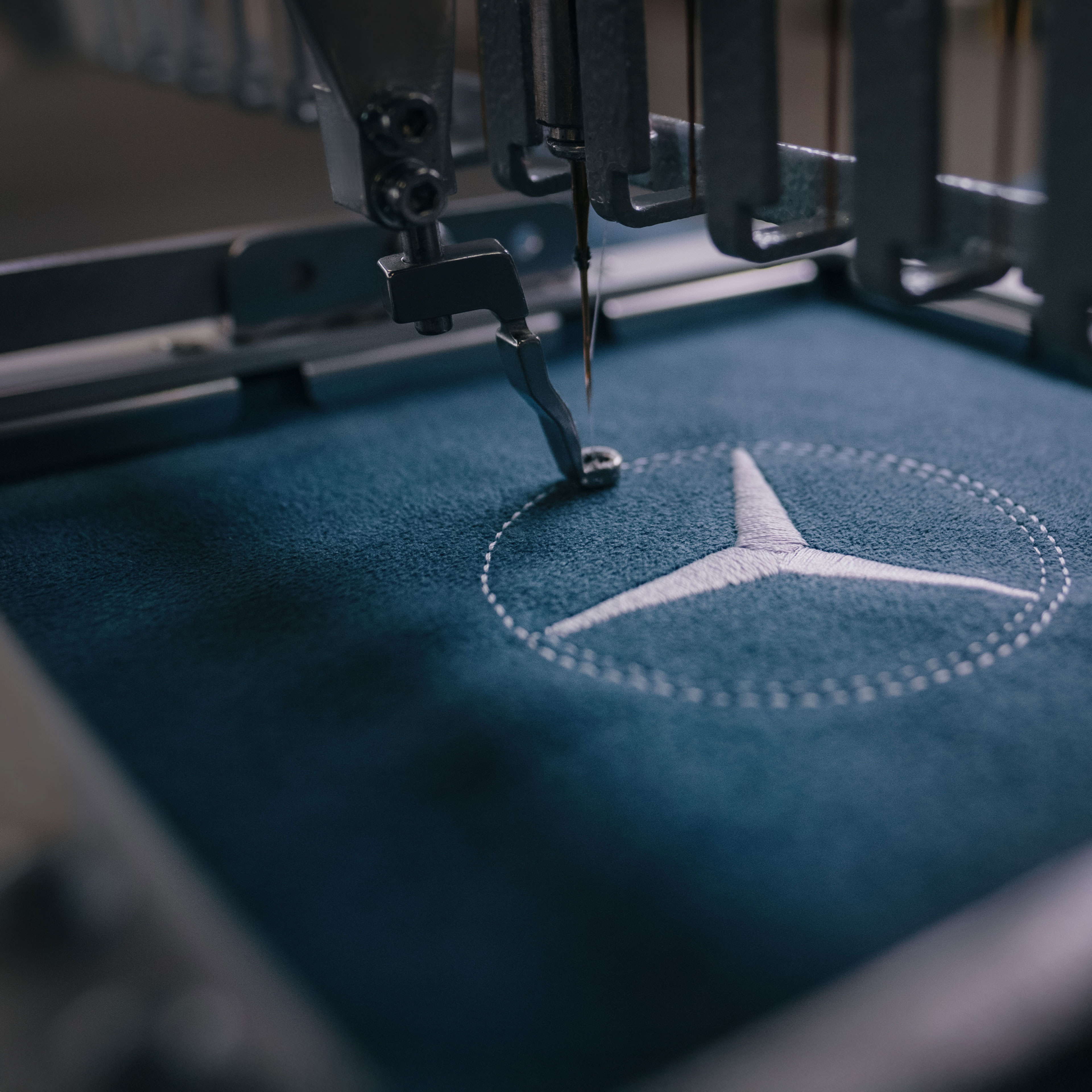 MANUFAKTUR | Mercedes-Benz Hvězda Mercedes-Benz je přišitá na tkaninu.