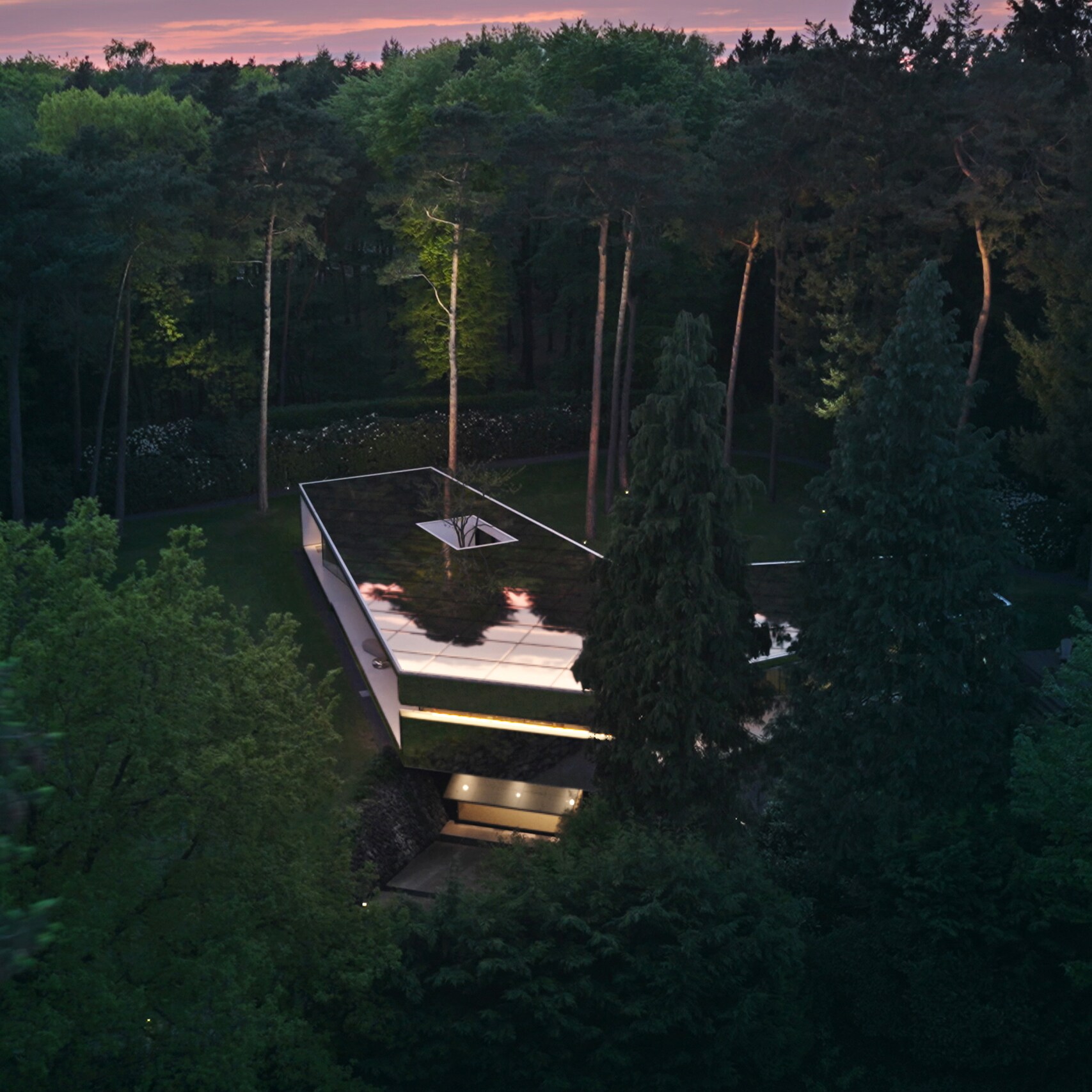 Bílý architektonicky zajímavý dům s&nbsp;vjezdem a&nbsp;garáží na předměstí.