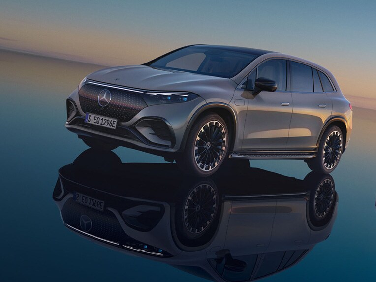 Plně elektrické EQS SUV od Mercedes-Benz stojící ve svém světě EQS SUV se zrcadlícím se povrchem.