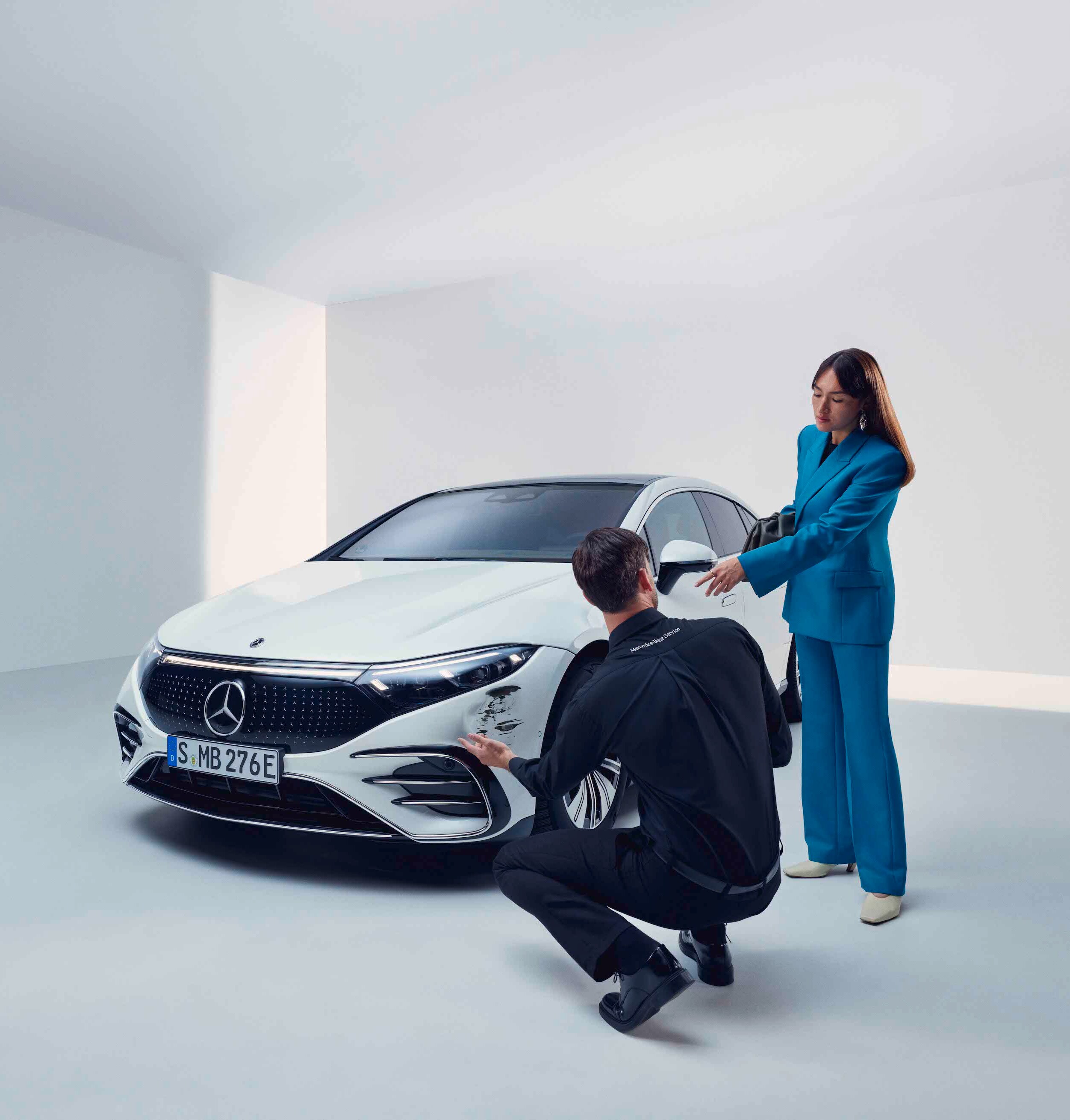 Žena nechává svůj vůz Mercedes-Benz zkontrolovat zaměstnancem servisu.
