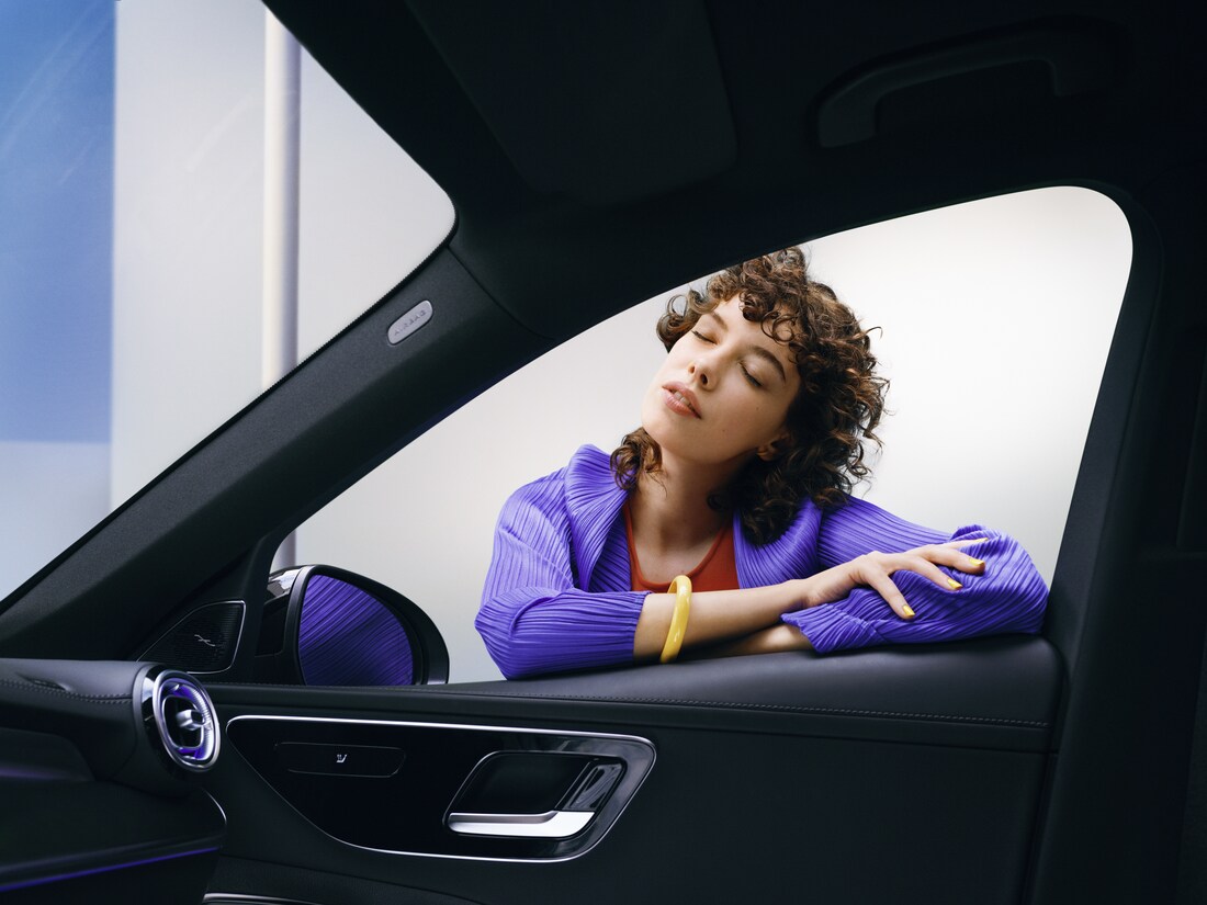 Žena má radost ze svého čistého vozu Mercedes-Benz.
