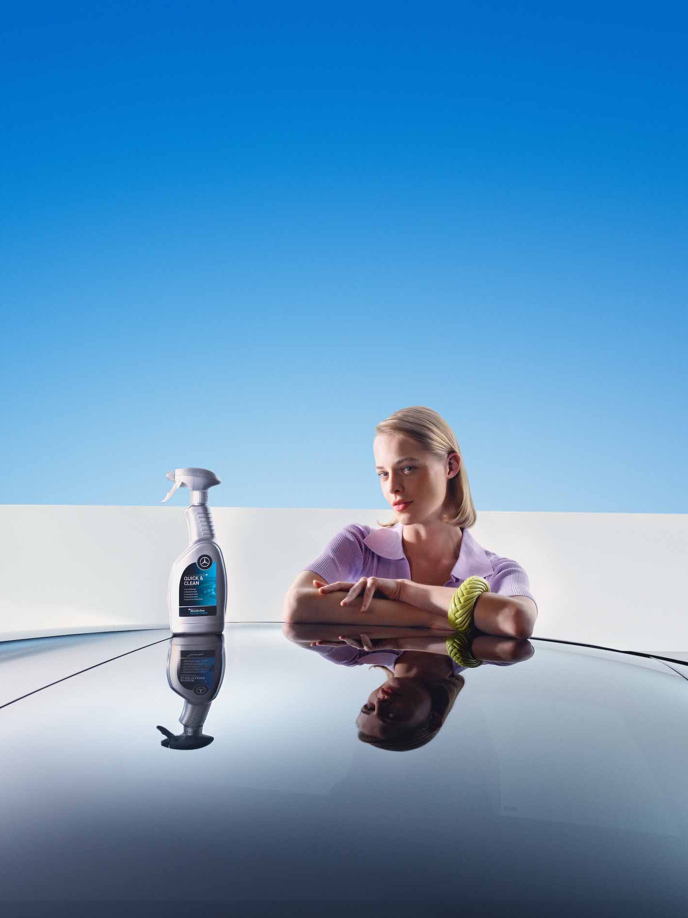 Žena se opírá o svůj čerstvě umytý Mercedes-Benz.
