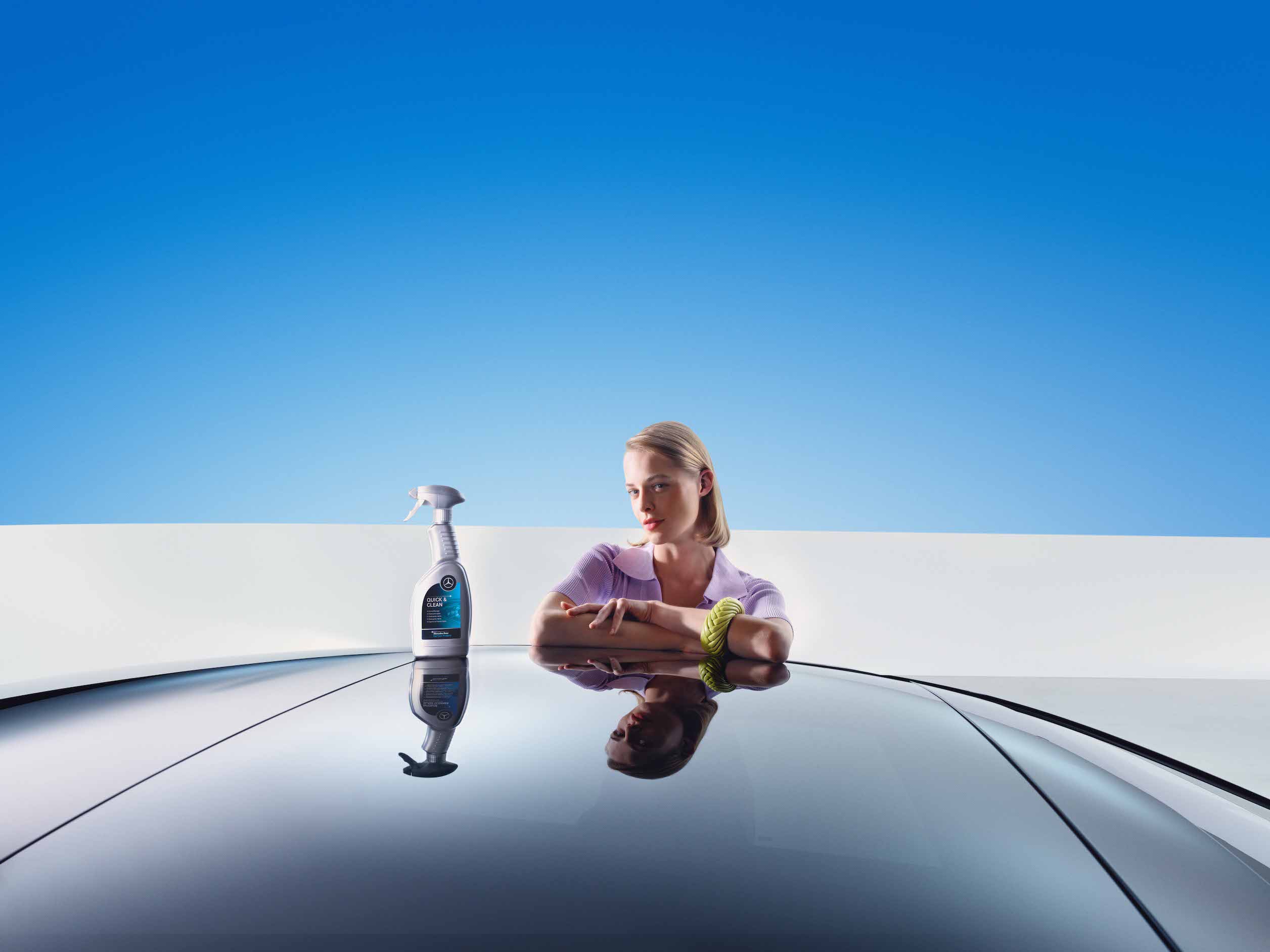 Mercedes-Benz | Originální prostředky pro péči Žena se opírá o svůj čerstvě umytý Mercedes-Benz.