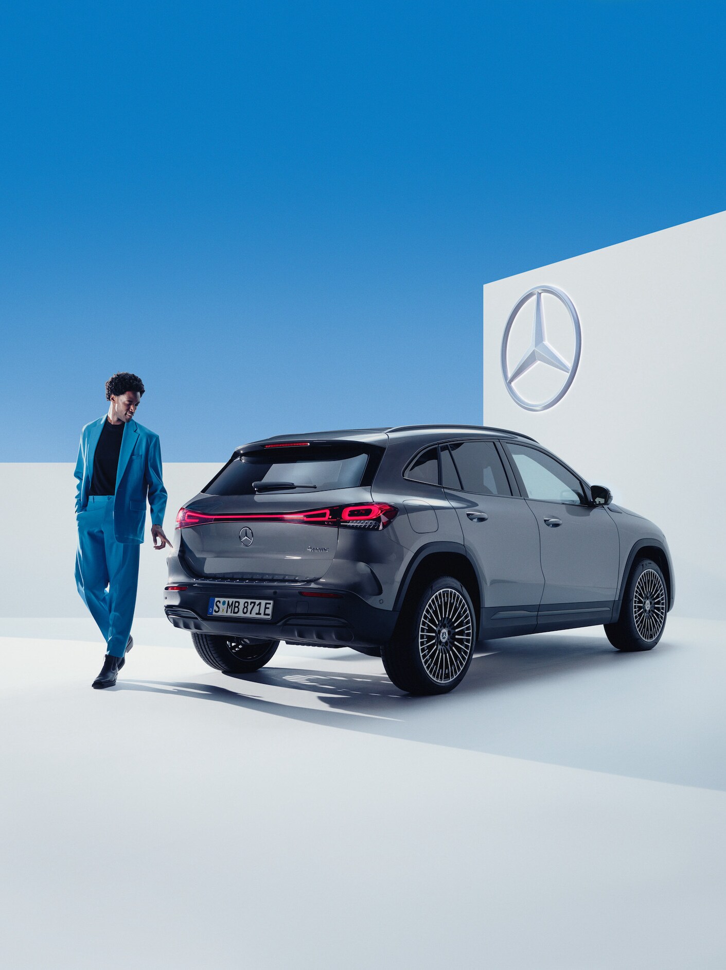 Muž prochází kolem svého vozu Mercedes-Benz.