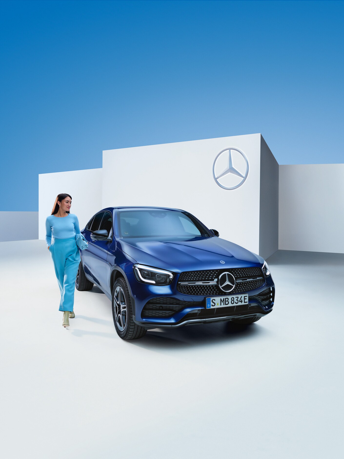 Žena stojí vedle svého vozu Mercedes-Benz.