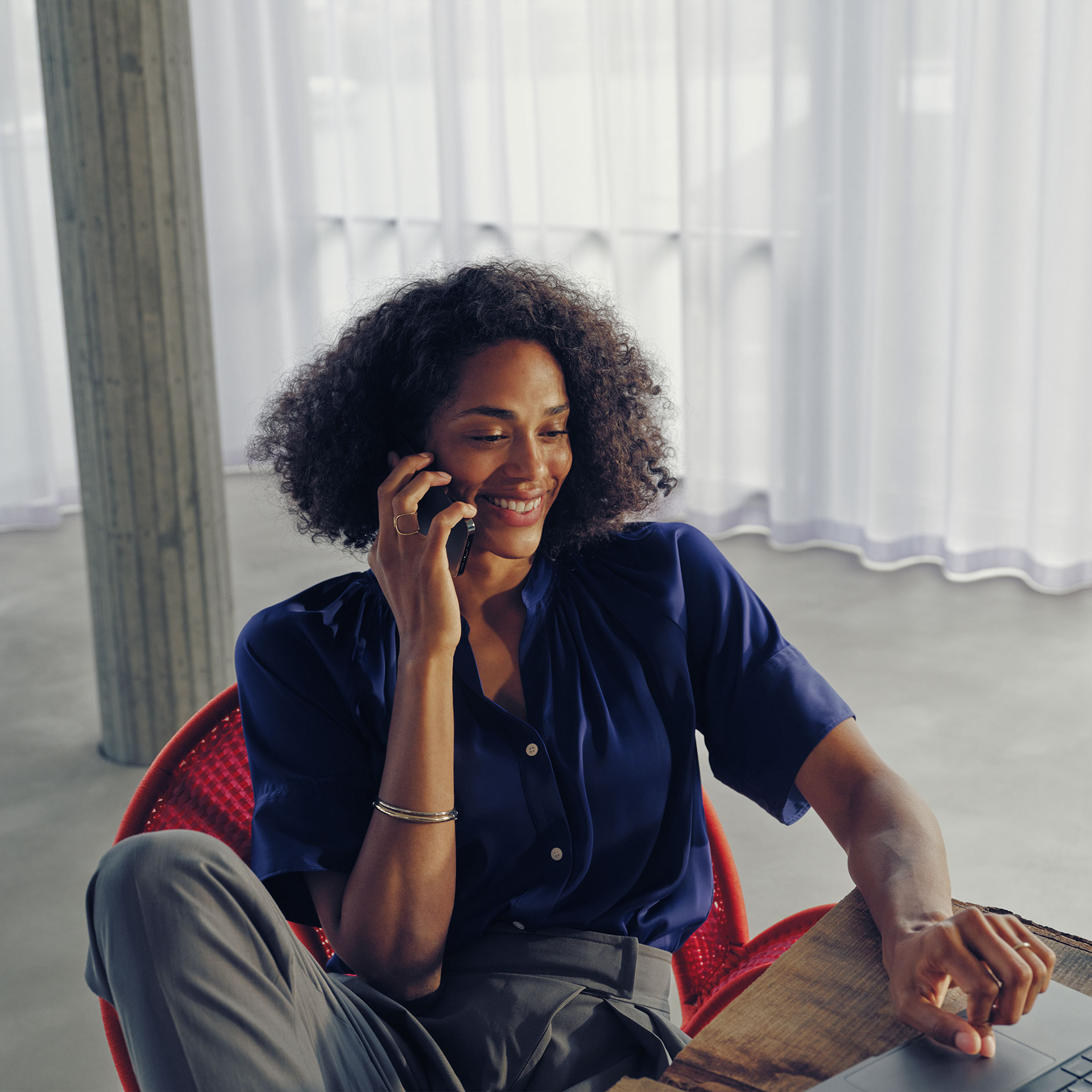 Otázky | Nabíjení | Mercedes-Benz Žena sedí u stolu a telefonuje.