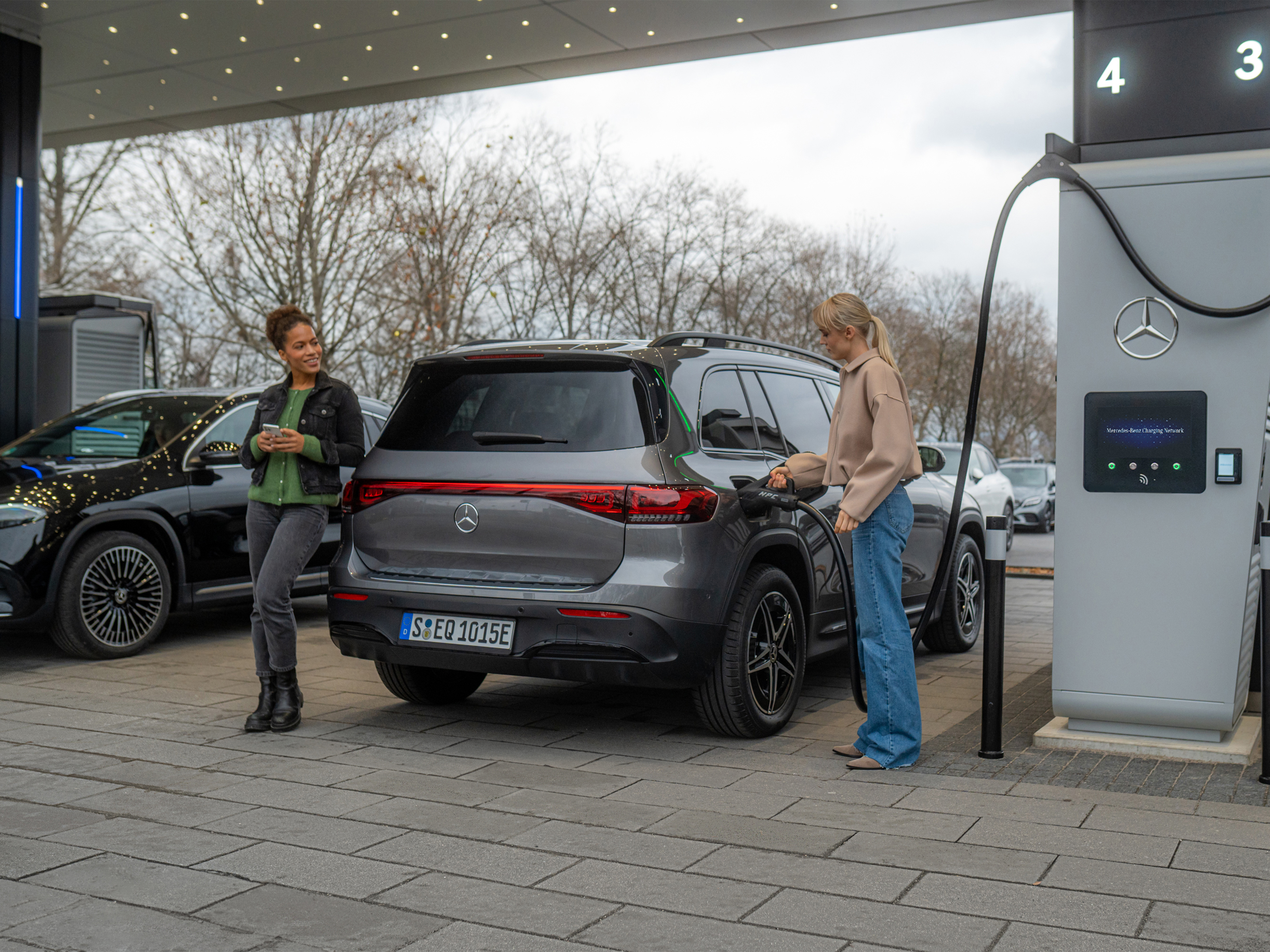 Nabíjecí síť Mercedes-Benz | Nabíjení na cestách | Mercedes-Benz Dva elektromobily Mercedes-Benz na nabíjecí stanici.