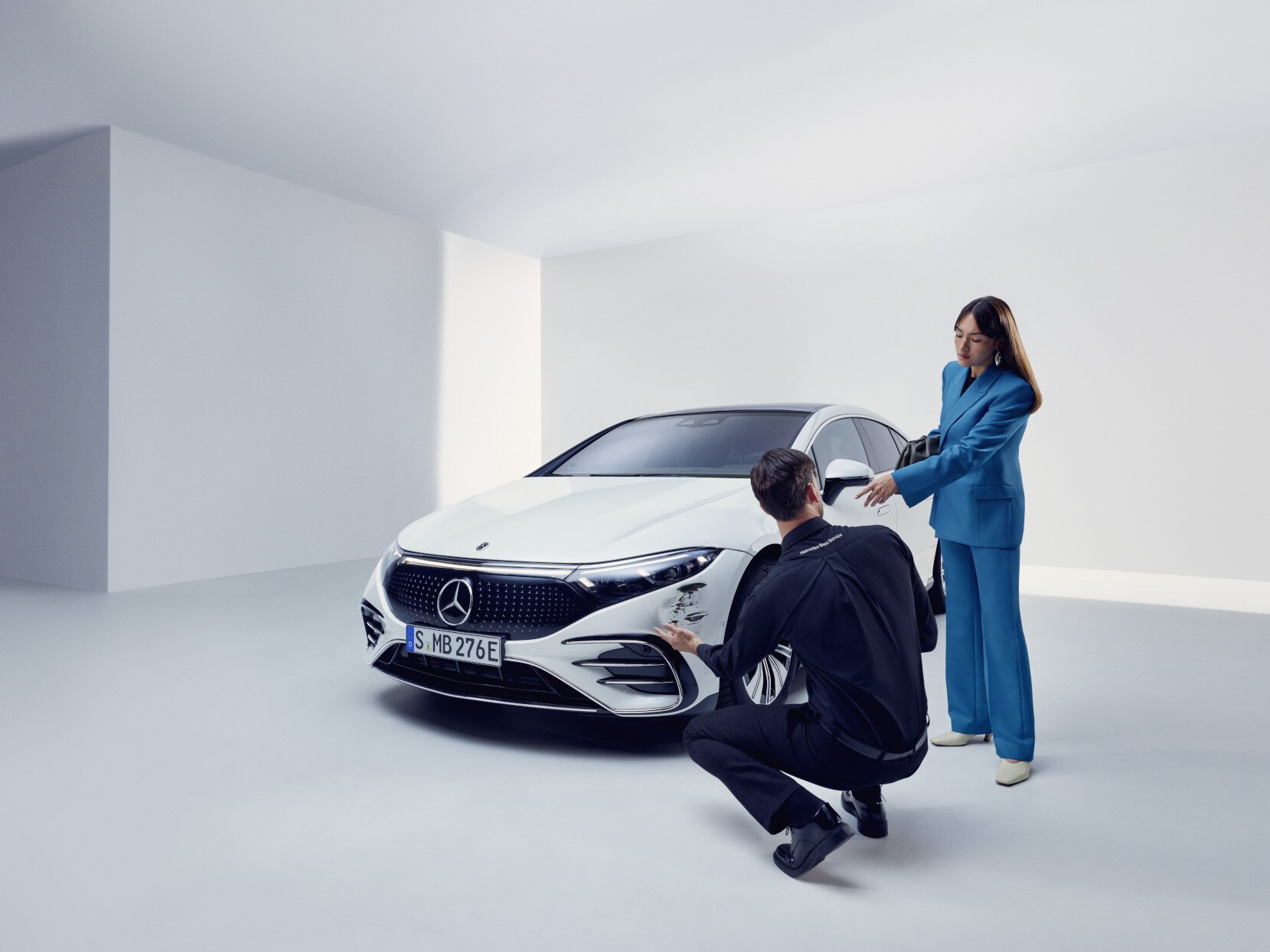 Osoba z&nbsp;týmu podpory Mercedes-Benz klečí u&nbsp;poškozeného vozidla Mercedes-Benz.