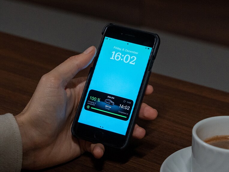 Muž držící chytrý telefon s aplikací Mercedes-Benz.