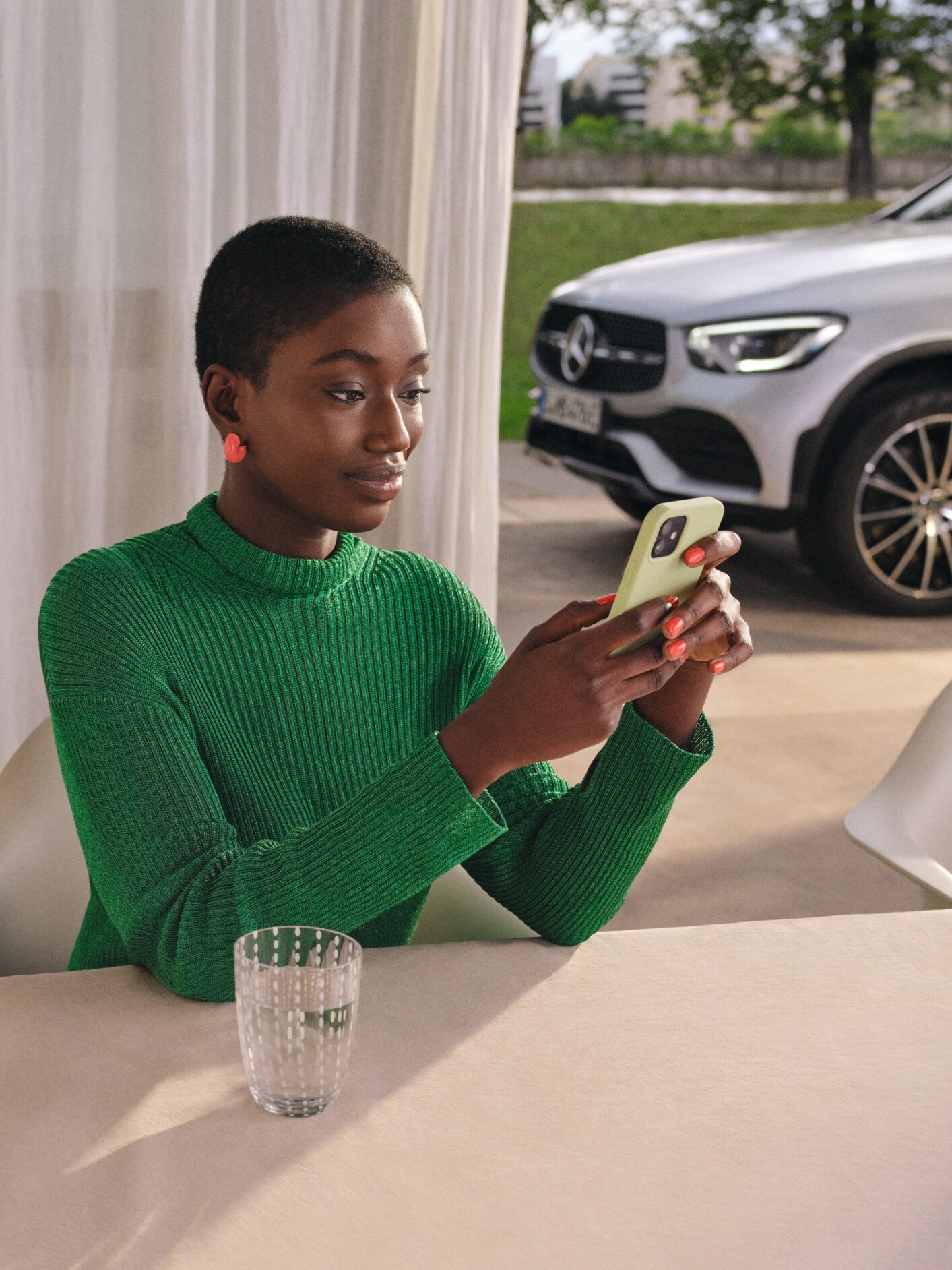 Žena kontroluje pomocí chytrého telefonu stav svého vozidla.