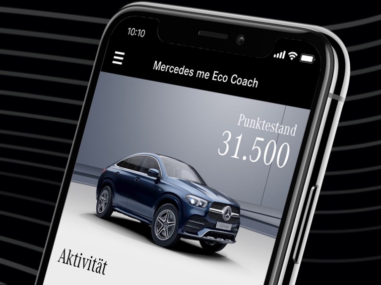 Na chytrém telefonu je otevřena aplikace Mercedes me Eco Coach a zobrazí se stav bodů dosažený obzvláště ekologicky šetrným způsobem jízdy. Na chytrém telefonu je otevřena aplikace Mercedes me Eco Coach a zobrazí se stav bodů dosažený obzvláště ekologicky šetrným způsobem jízdy.