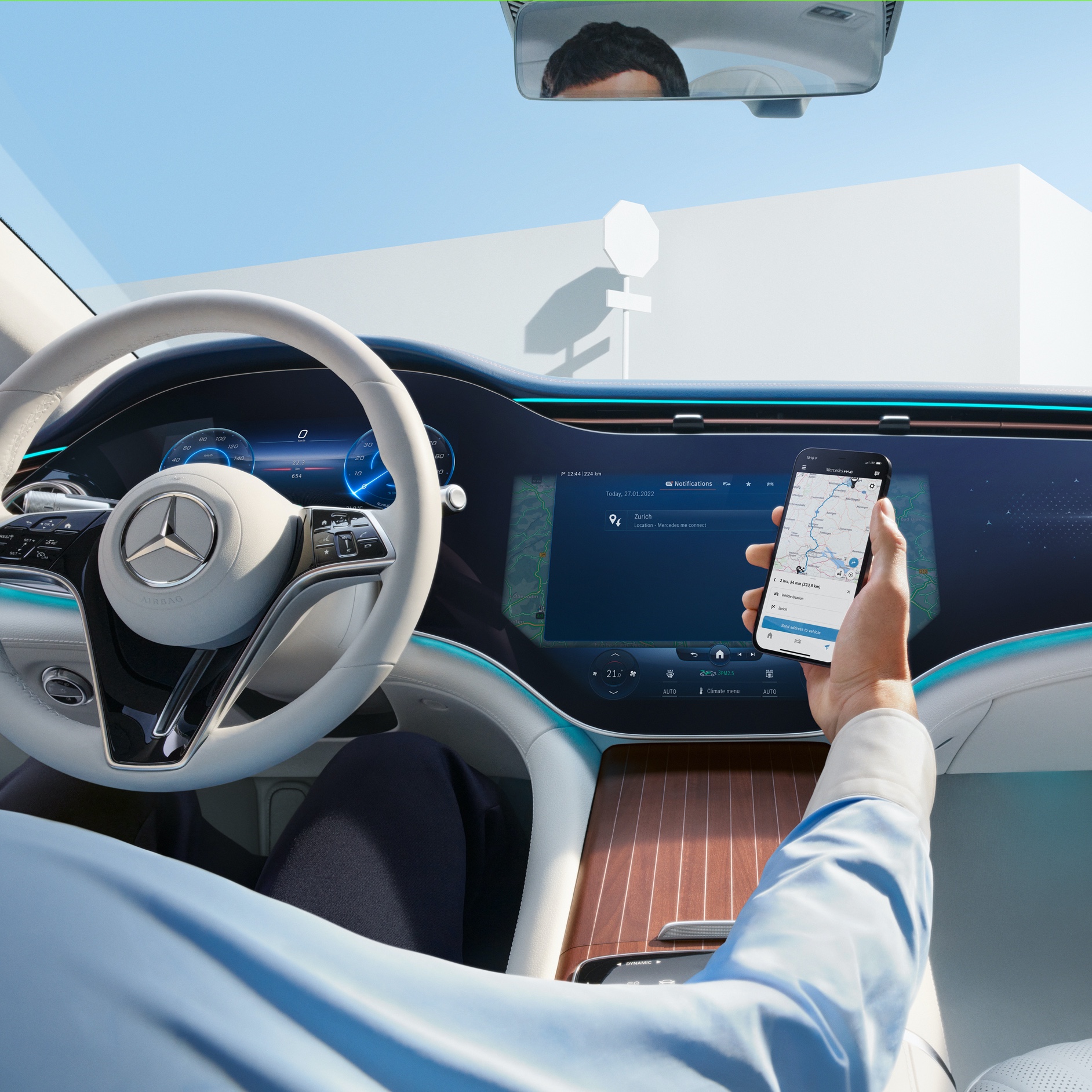 Muž přenáší zvolenou trasu ze svého chytrého telefonu prostřednictvím digitálních doplňků k tématu navigace na MBUX Hyperscreen ve svém voze Mercedes-Benz. Muž posílá trasu ze svého chytrého telefonu do navigace ve voze.