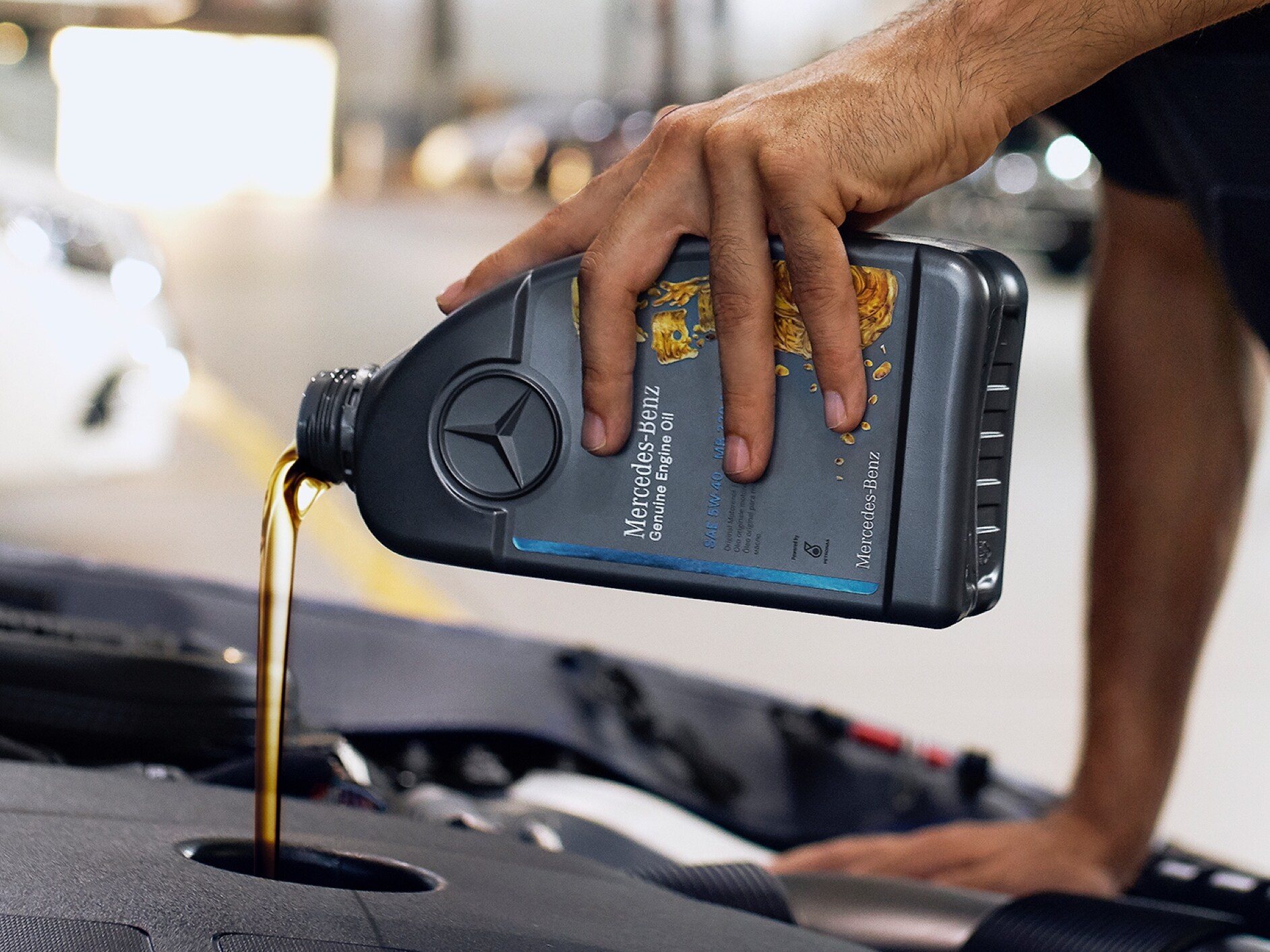 Osoba, která nalévá motorový olej do vozu Mercedes-Benz.