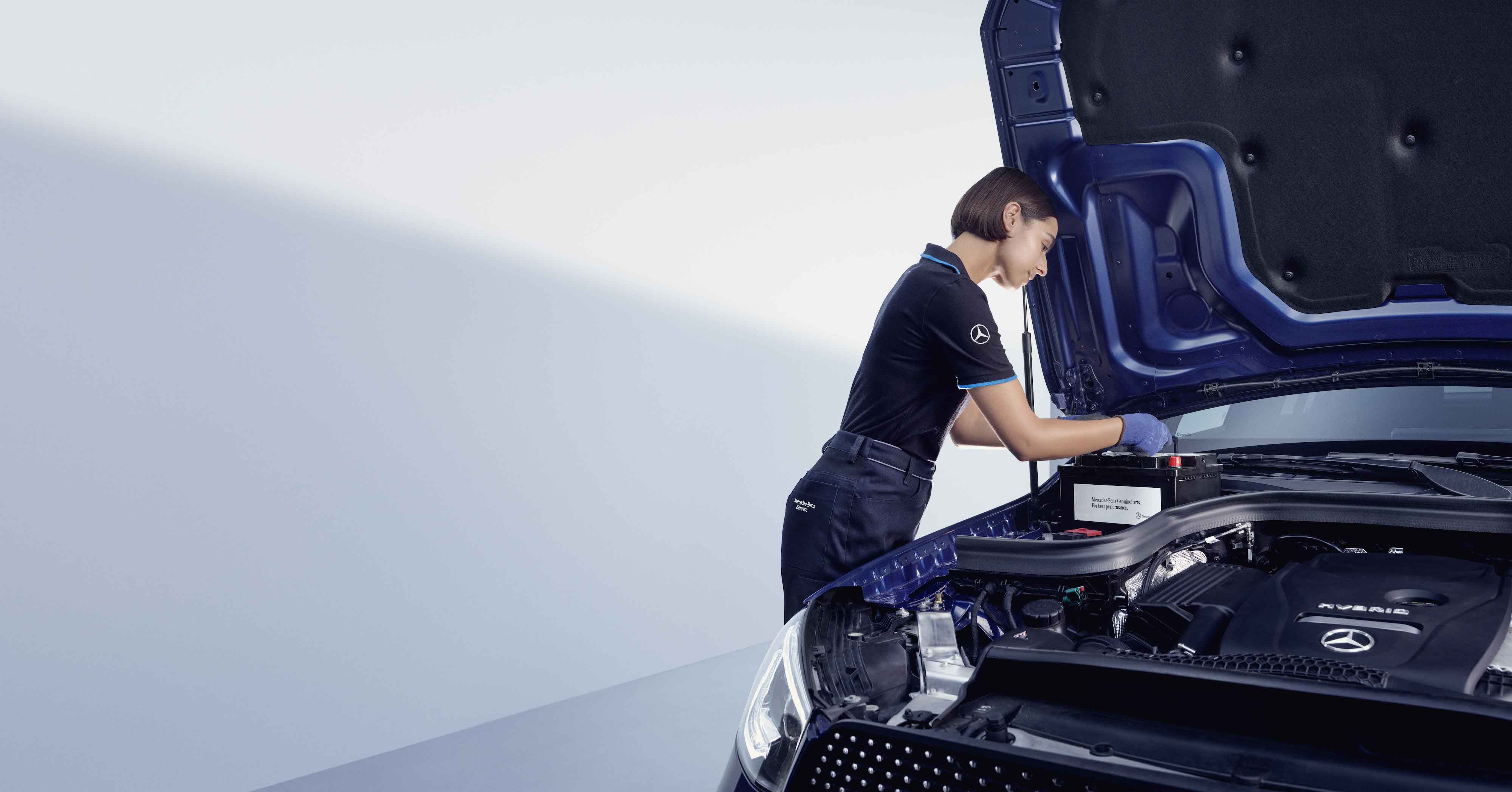 Originální díly Mercedes-Benz Automechanik se sklání nad otevřenou kapotou vozu Mercedes-Benz.