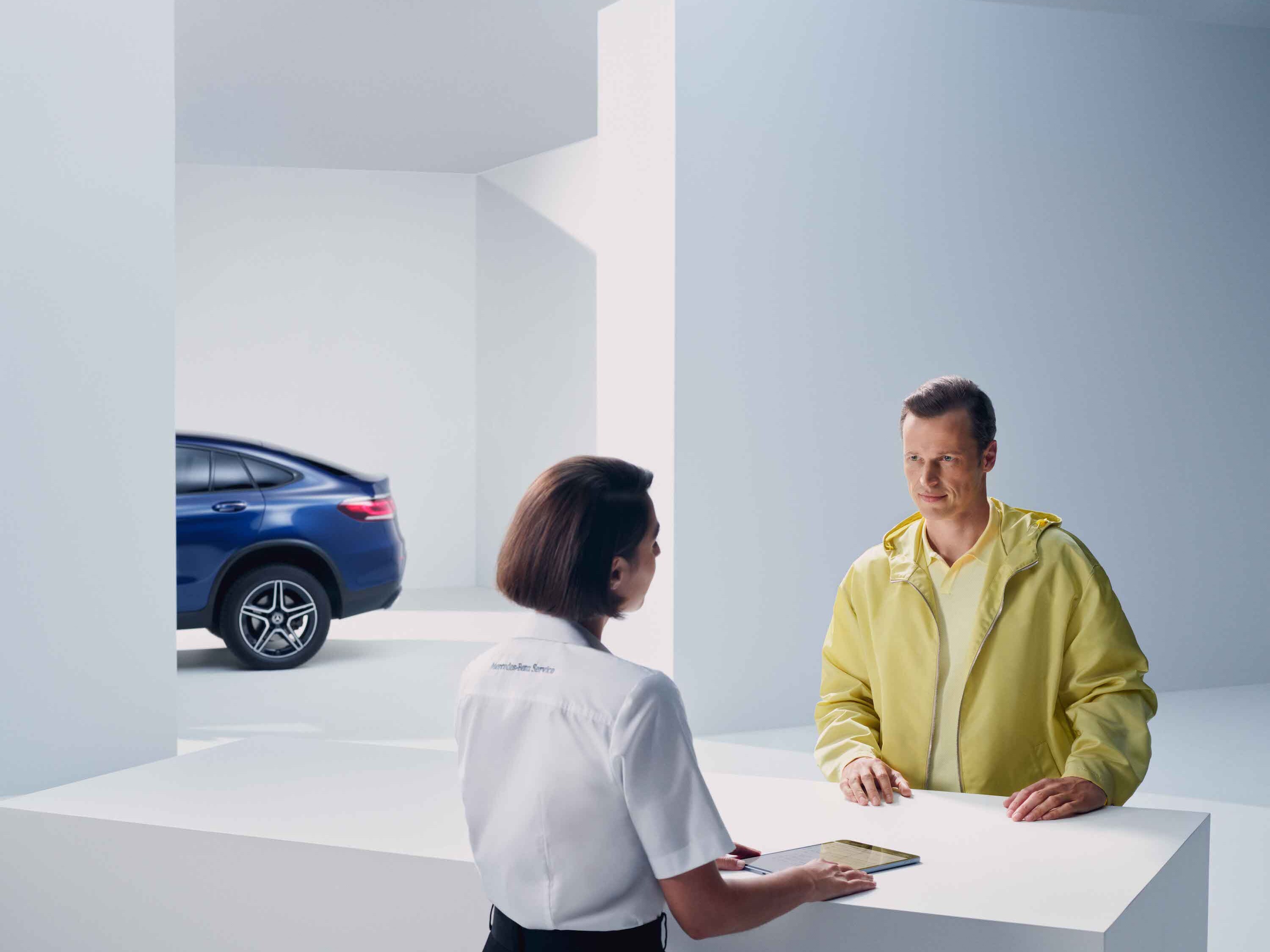 Člověk dostává radu od zaměstnance Mercedes-Benz.