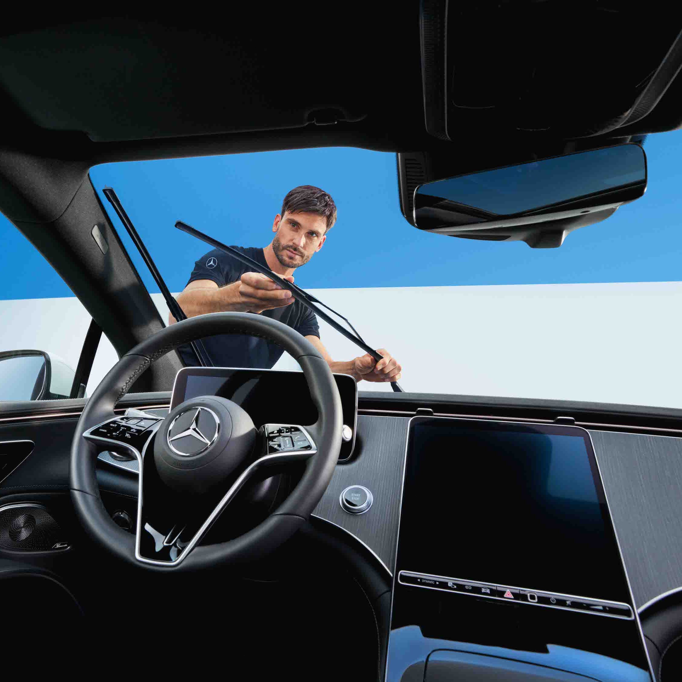 Technik Mercedes-Benz vyměňuje stěrače na vozidle.