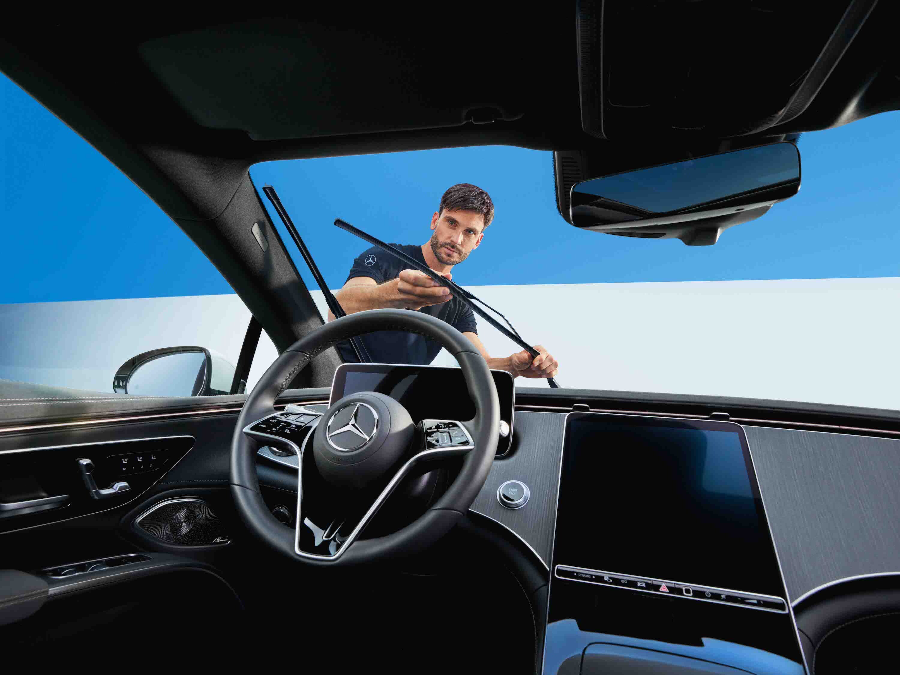 Osoba upravující stěrače na vozidle Mercedes-Benz.