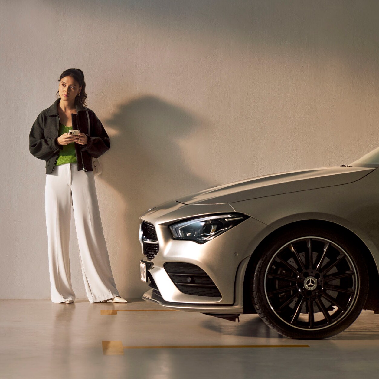 Osoba stojí před vozidlem Mercedes-Benz.