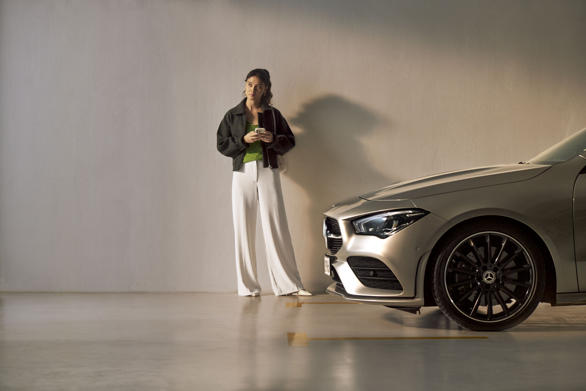 Service Select | Mercedes-Benz Osoba stojí před vozidlem Mercedes-Benz.