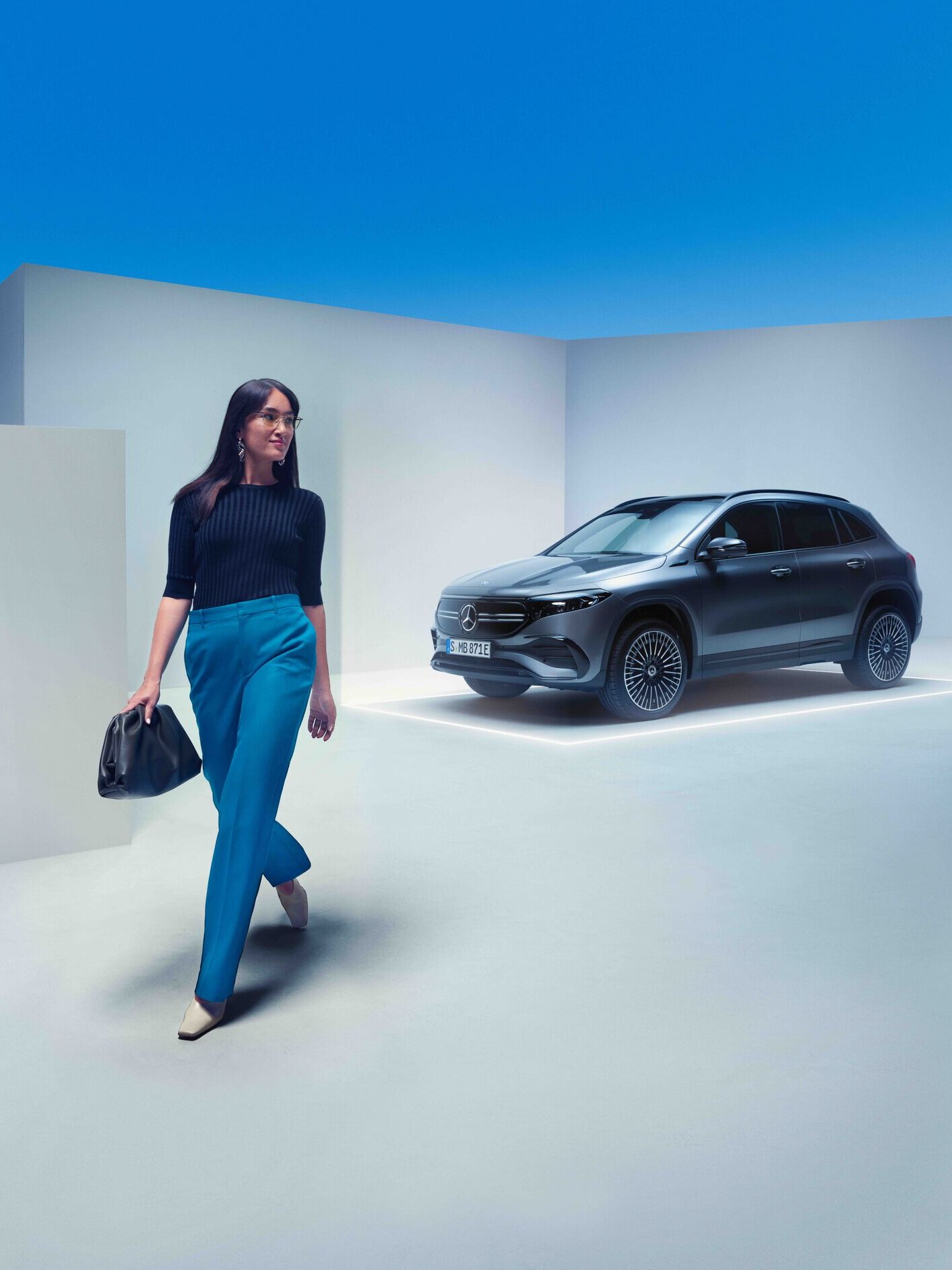 Žena kráčí podél vozu Mercedes-Benz.