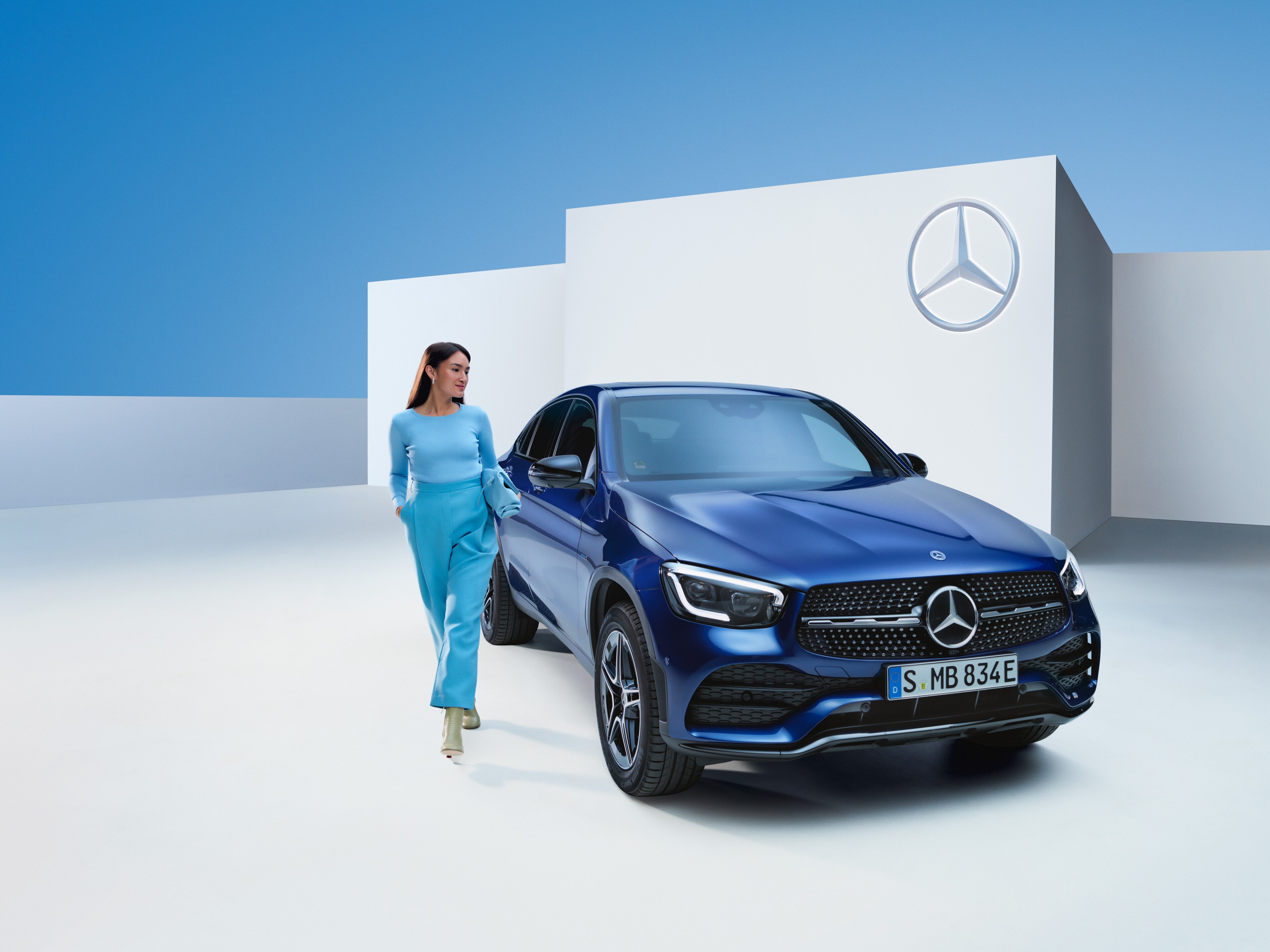 Žena kráčí vedle svého vozidla Mercedes-Benz.