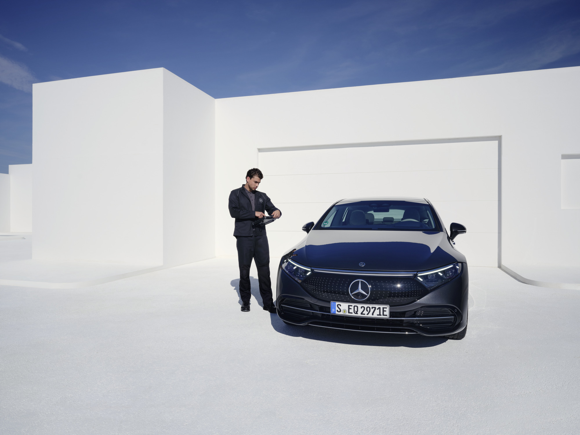 Údržba elektromobilů | Mercedes-Benz Technik Mercedes-Benz prohlíží vůz Mercedes-Benz.