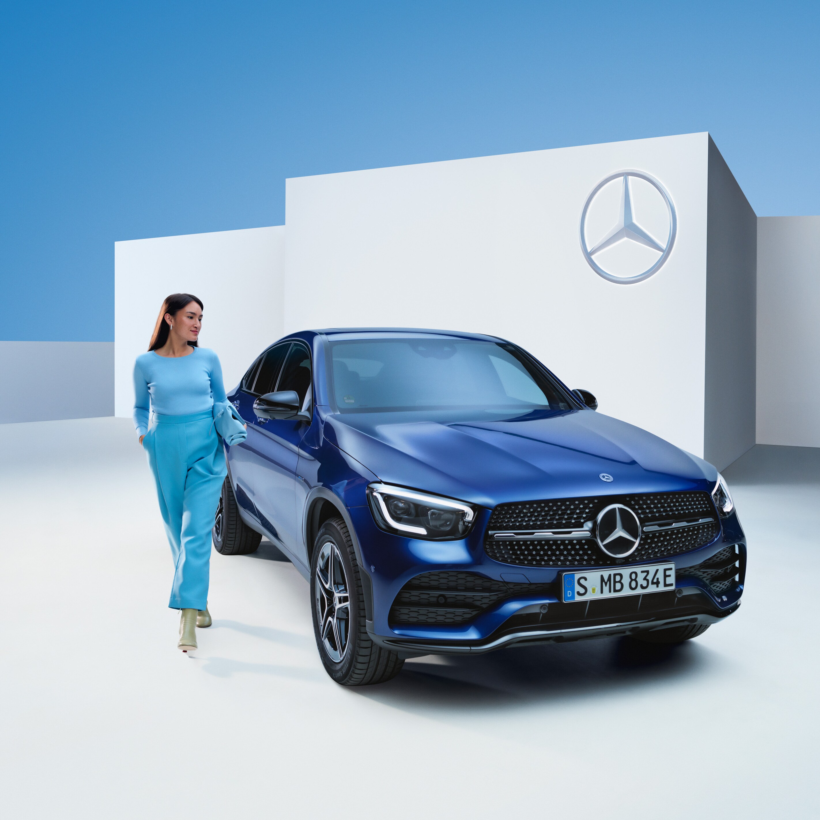 Osoba jdoucí vedle vozidla Mercedes-Benz.