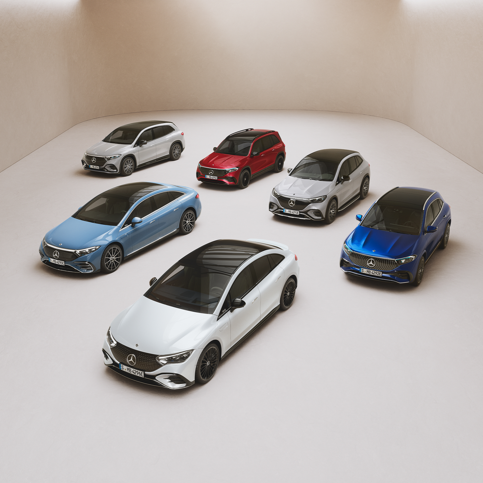 Modely EQ Range od Mercedes-Benz. Modely sedanu EQS, sedanu EQE, EQA, EQB a EQC jsou zaparkovány na zrcadlové ploše.