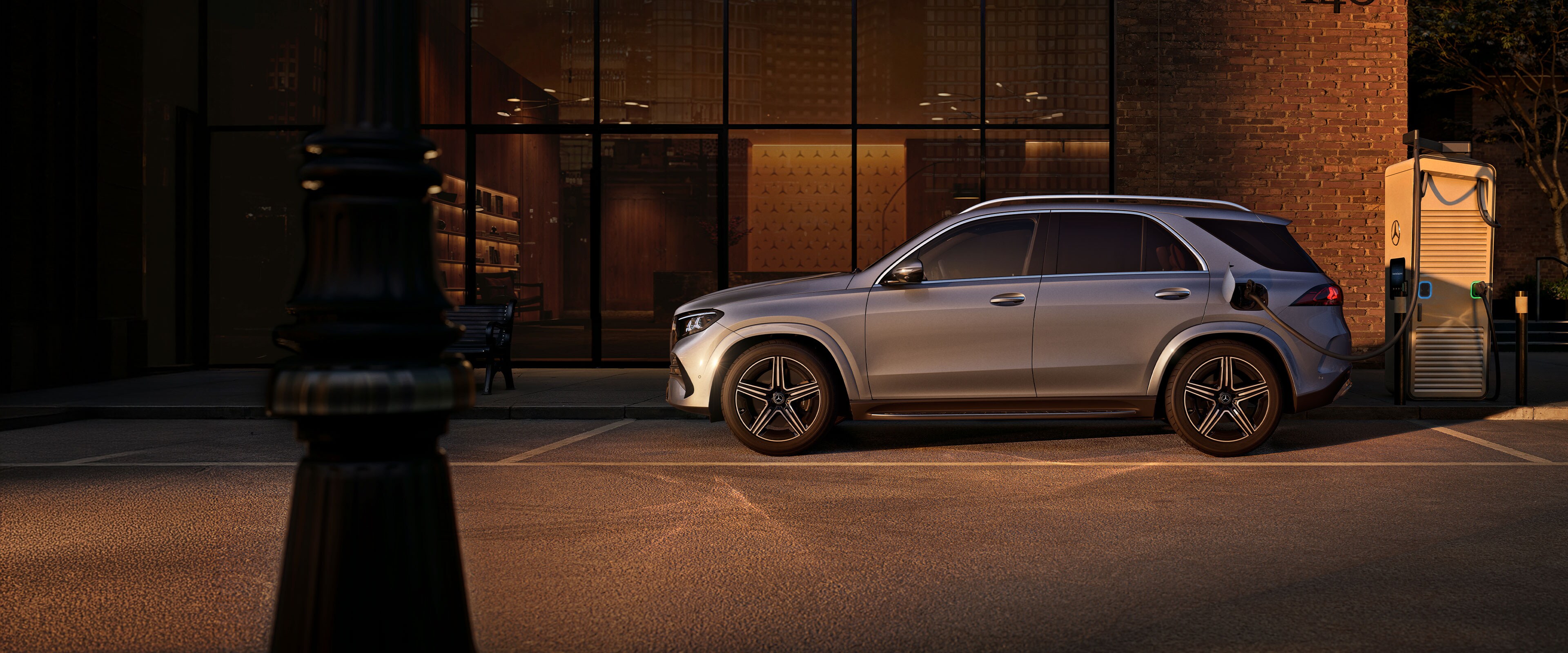 Mercedes-Benz GLE SUV při pohledu z boku před velkým domem.