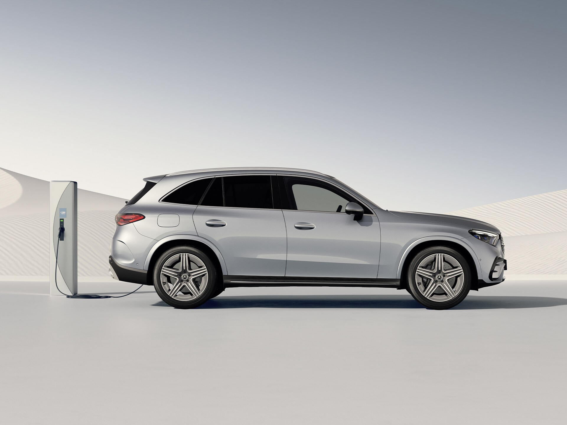 GLC SUV plug-in hybrid při pohledu z&nbsp;boku na nabíjecí stanici.