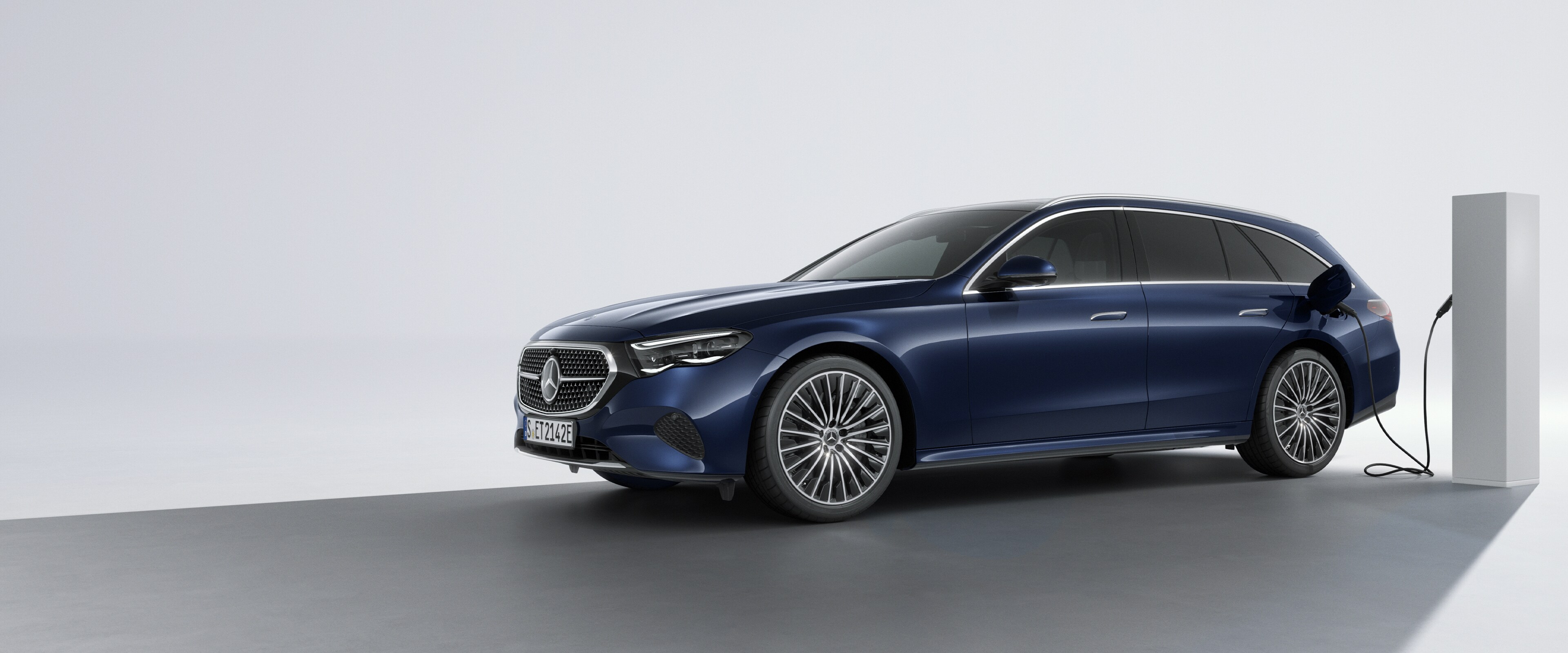 Vozidlo plug-in hybrid od Mercedes-Benz při bočním pohledu zezadu na nabíjecí stanici.