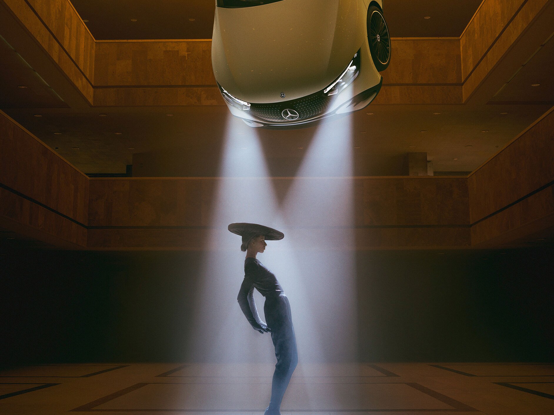 Žena v moderním outfitu pod rozsvícenými předními světly vozu Mercedes-Benz