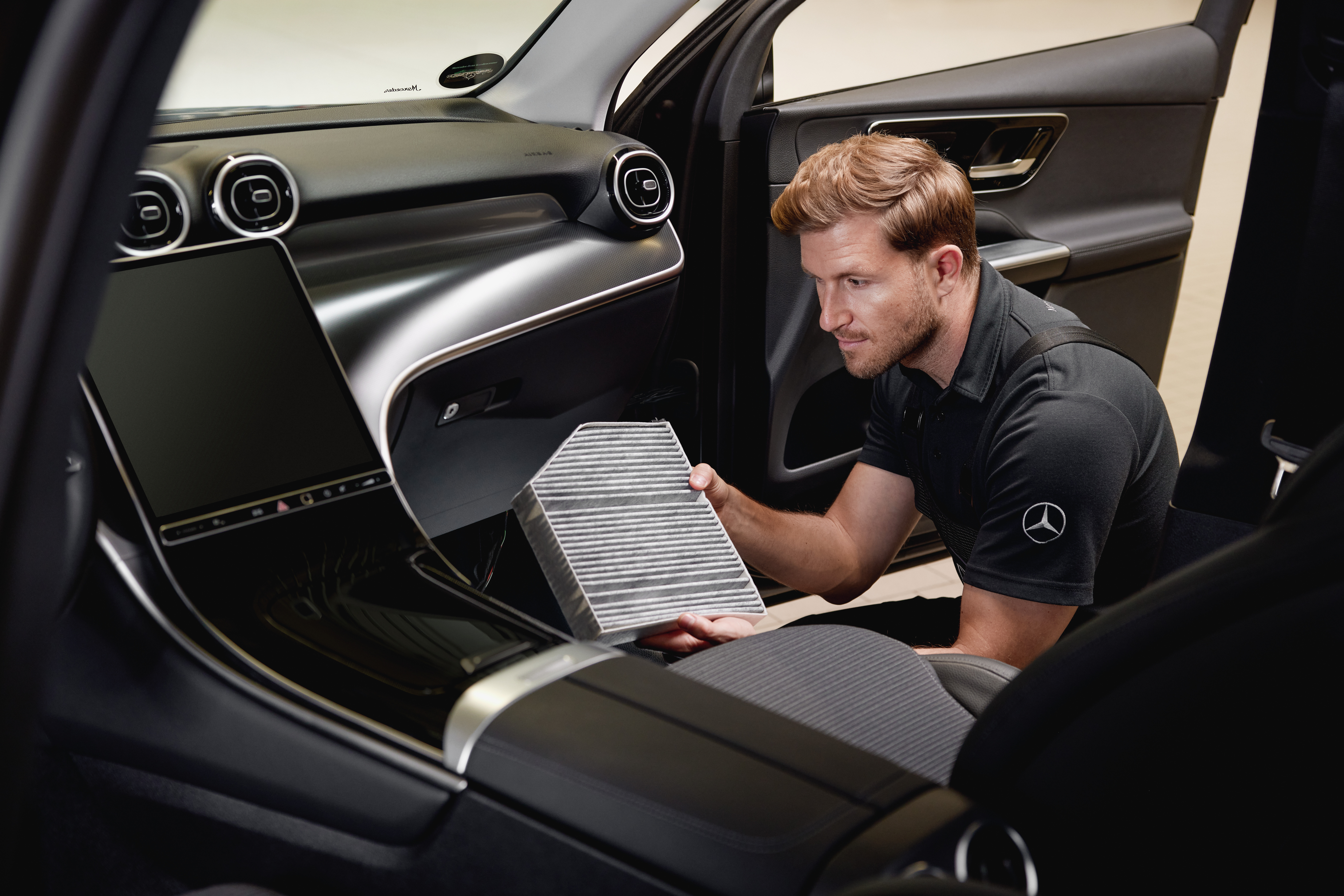 Kabinový vzduchový filtr | Mercedes-Benz Technik sedí ve voze Mercedes-Benz a kontroluje kabinový vzduchový filtr.