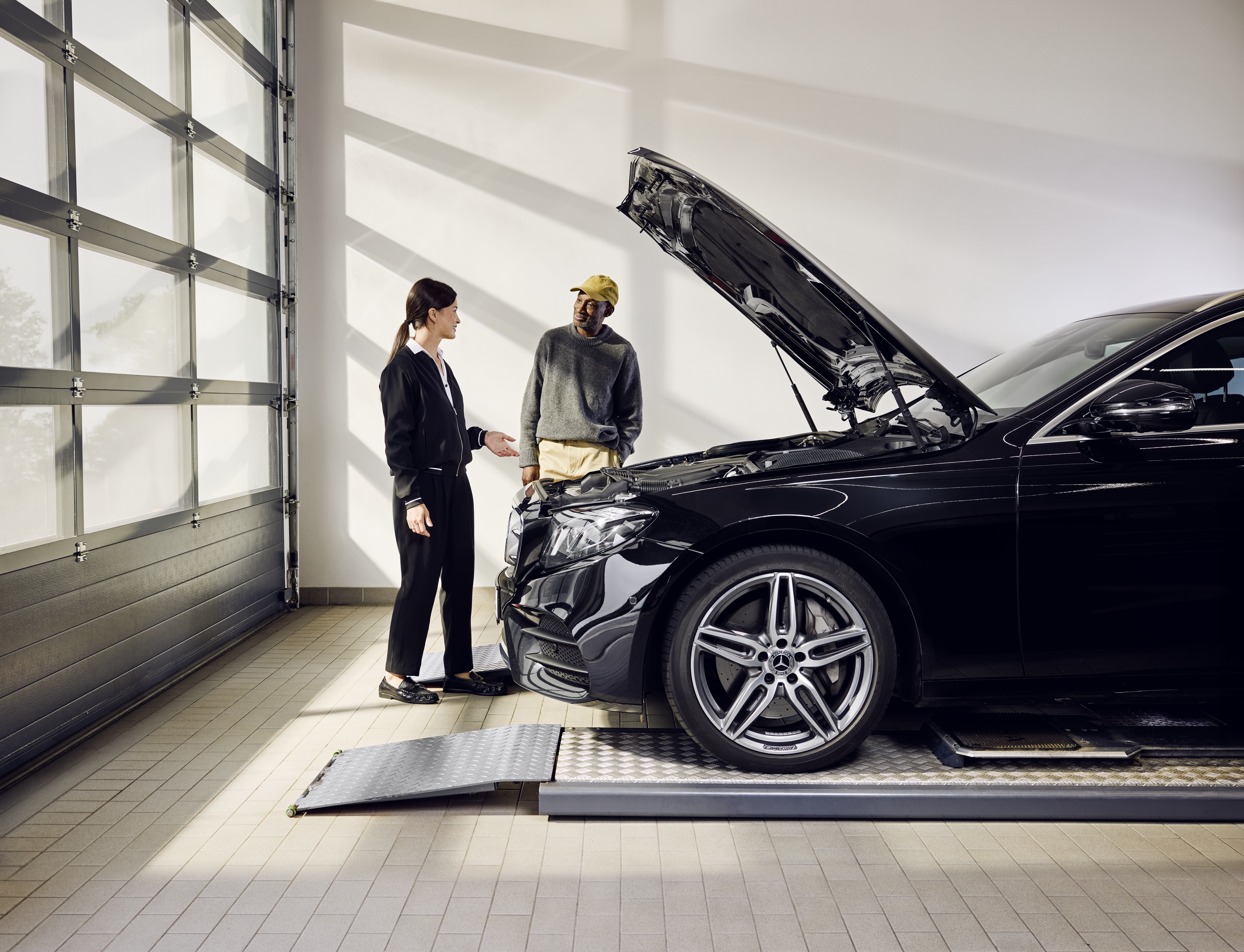 Výměna originálních dílů Mercedes-Benz Vozidlo Mercedes-Benz s otevřenou kapotou motoru umístěné na servisní rampě během profesionální výměny originálních dílů v servisním středisku.