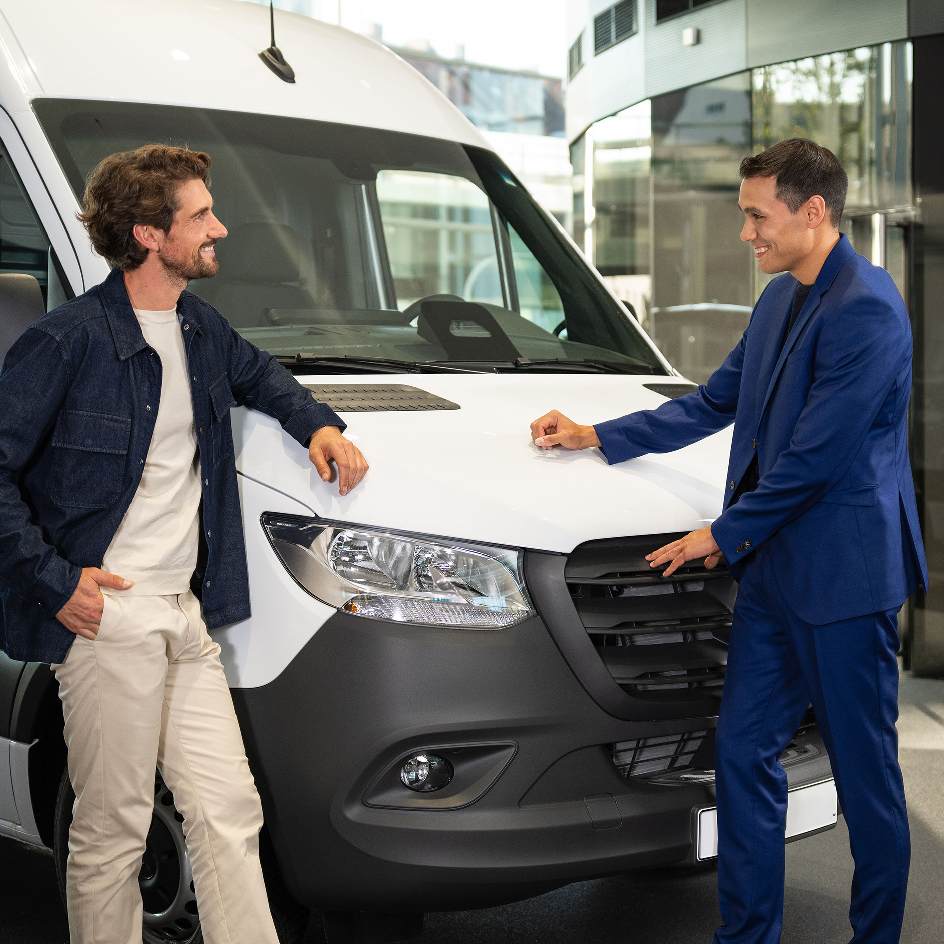Nové vozidlo | Leasing a financování | Finanční služby | Mercedes-Benz Muž hovoří s prodejcem Mercedes-Benz o bílém dodávkovém vozidle eSprinter