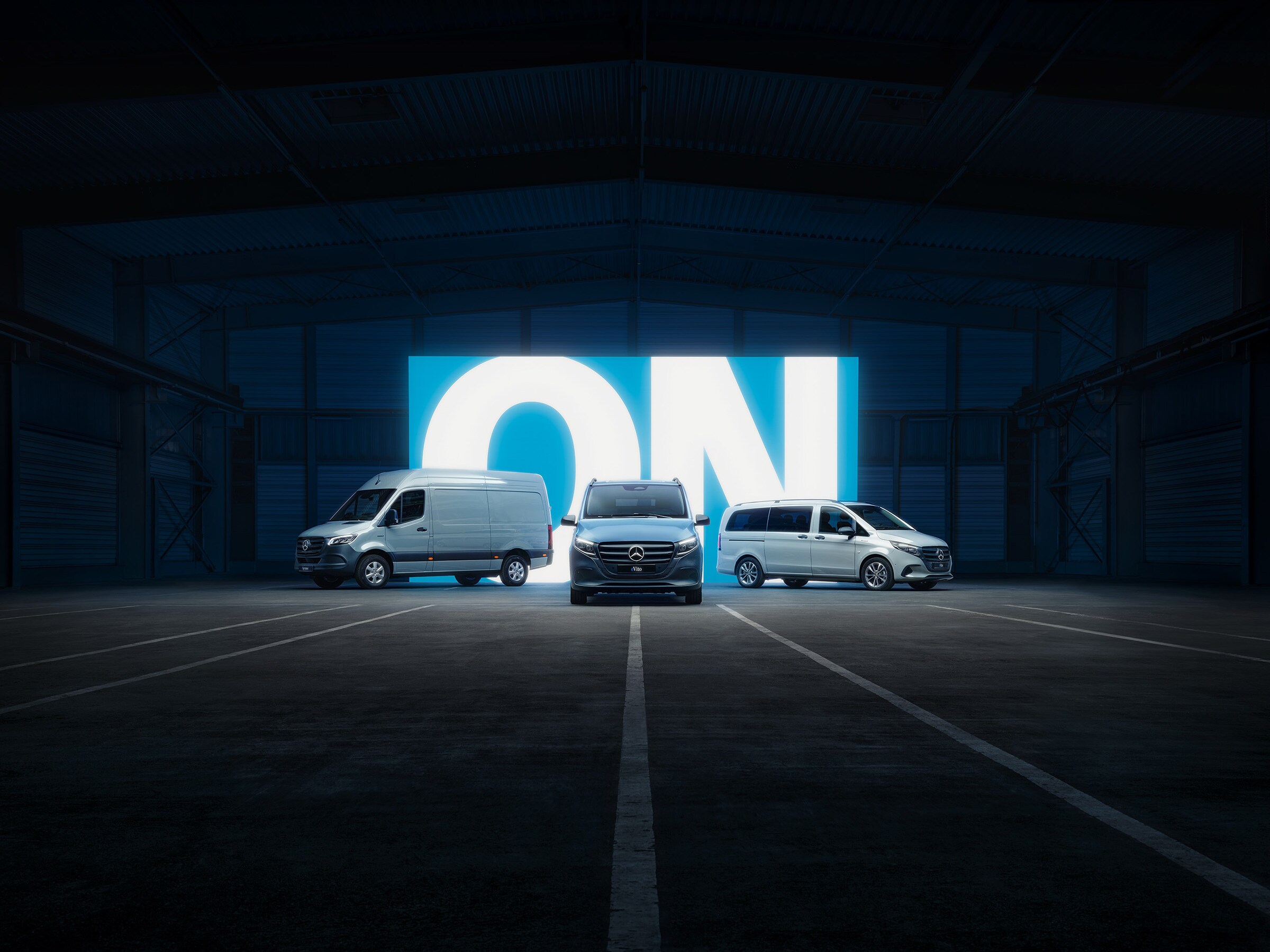 Řada elektrických dodávkových vozidel Mercedes-Benz s modely eSprinter a eVito v osvětleném showroomu.