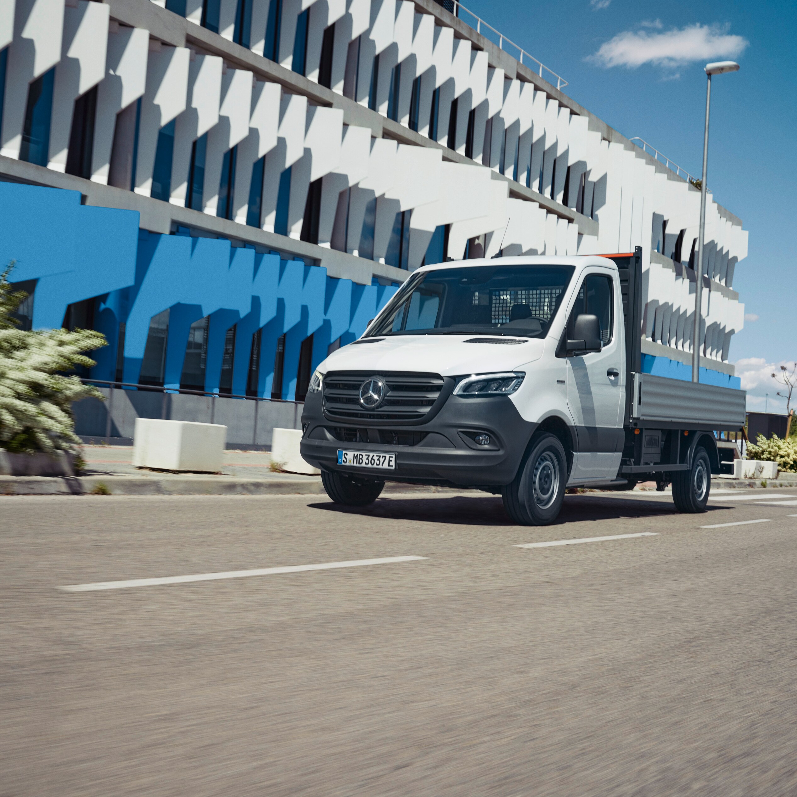 Valníkové vozidlo Mercedes-Benz eSprinter na cestě kolem města.