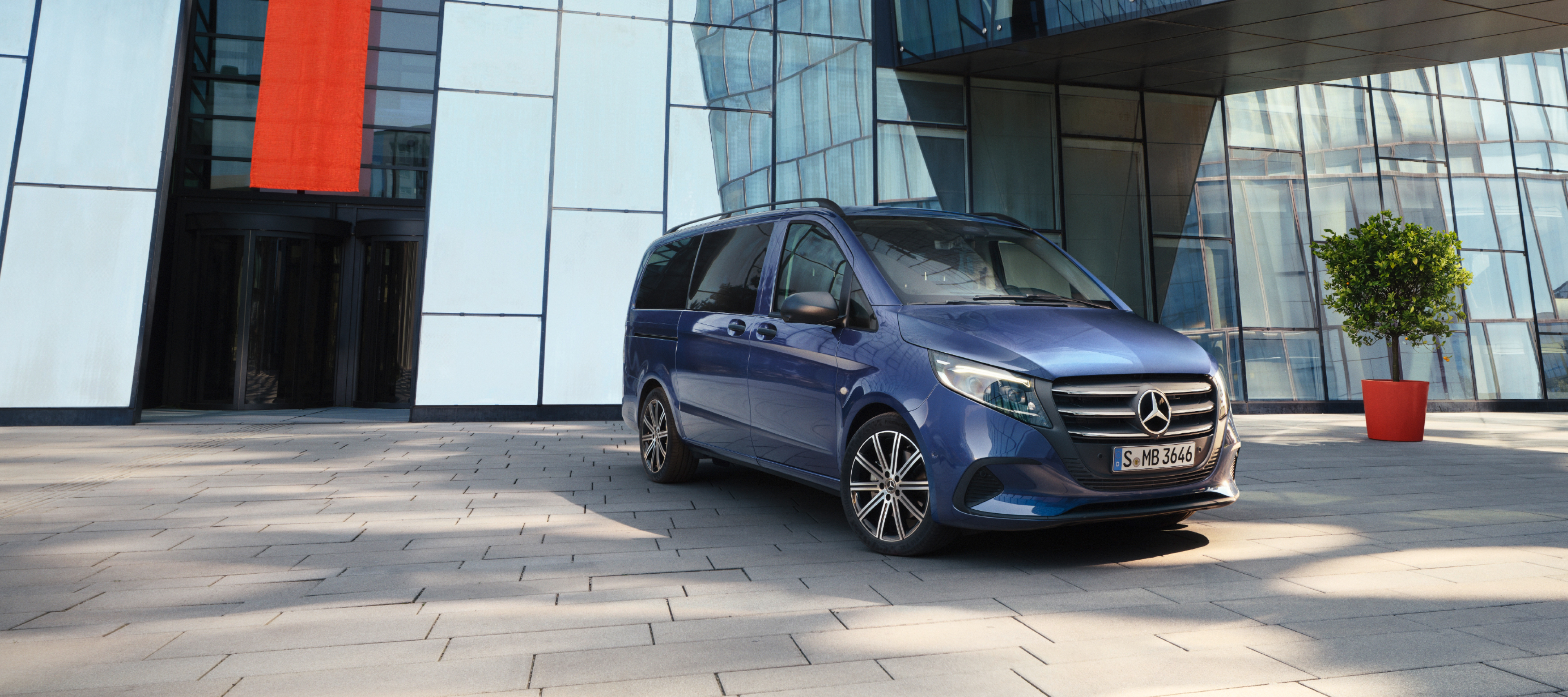 Porovnání vozidel | Vito Tourer | Mercedes-Benz Mercedes-Benz Vito Tourer před kancelářskou budovou.